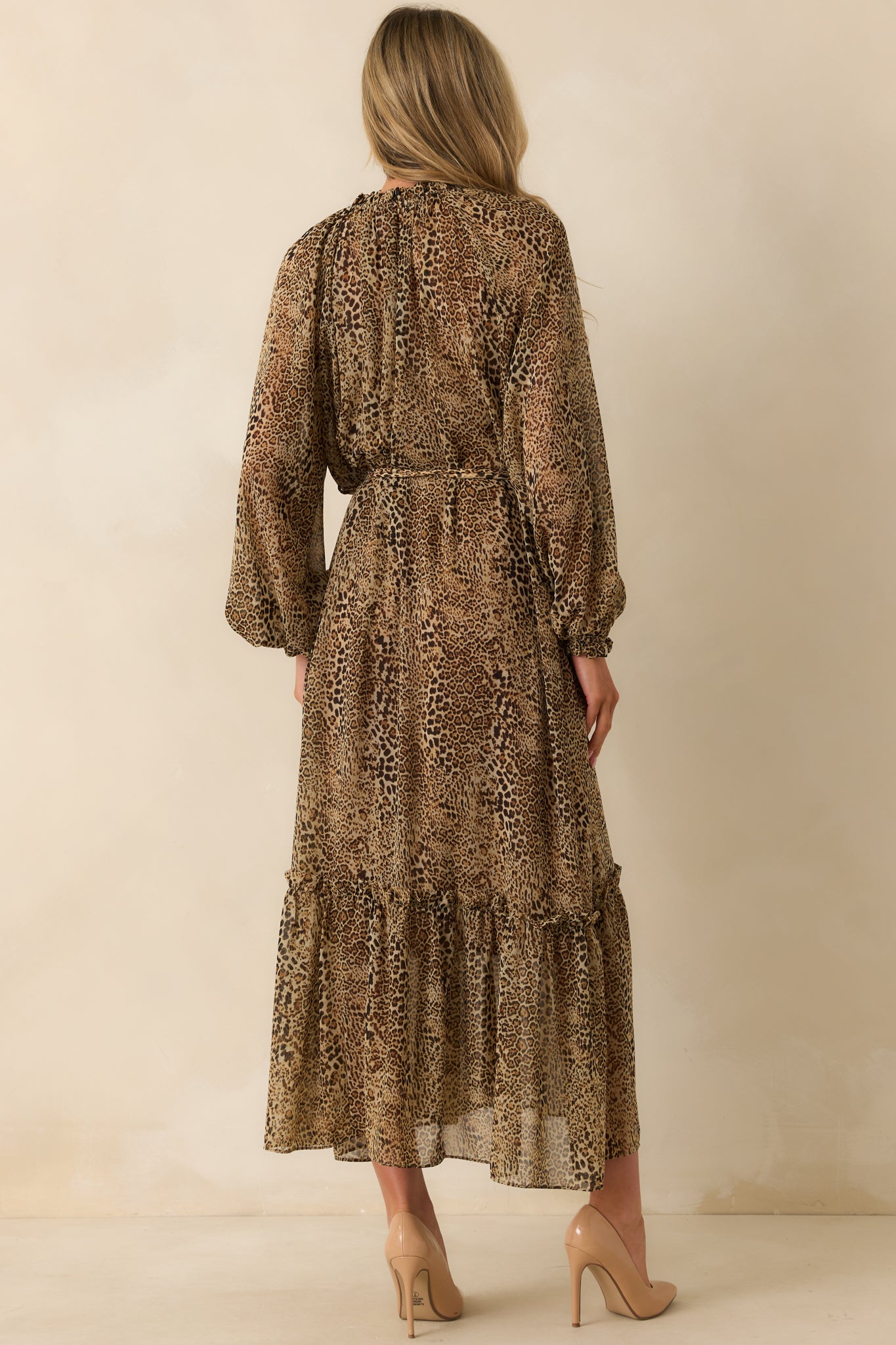 Rear view of the leopard print maxi dress showing the long sleeves, elastic cuffs, and flowing overlay