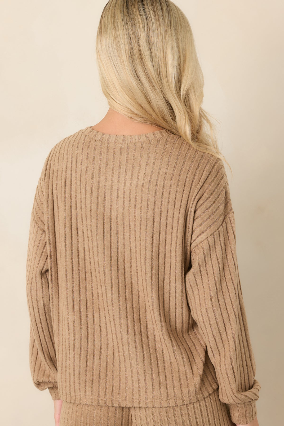Rear view of the light toffee rib knit top with dropped shoulders and long sleeves.