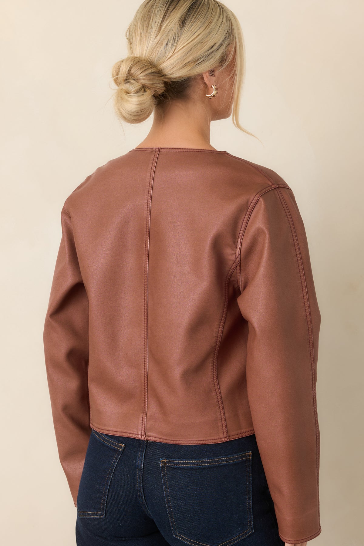 Rear view of the mauve faux leather cropped jacket showing its structured seaming and clean edges.