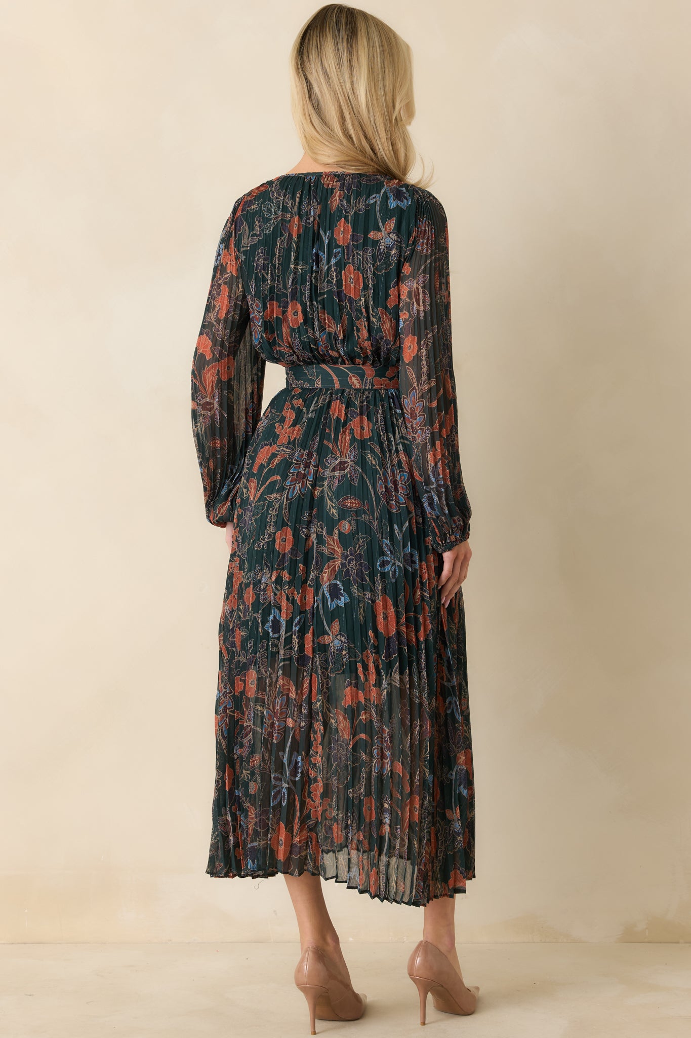 Back view of the maxi dress showing hidden zipper closure and pleated woven fabric continuing through the A-line silhouette.