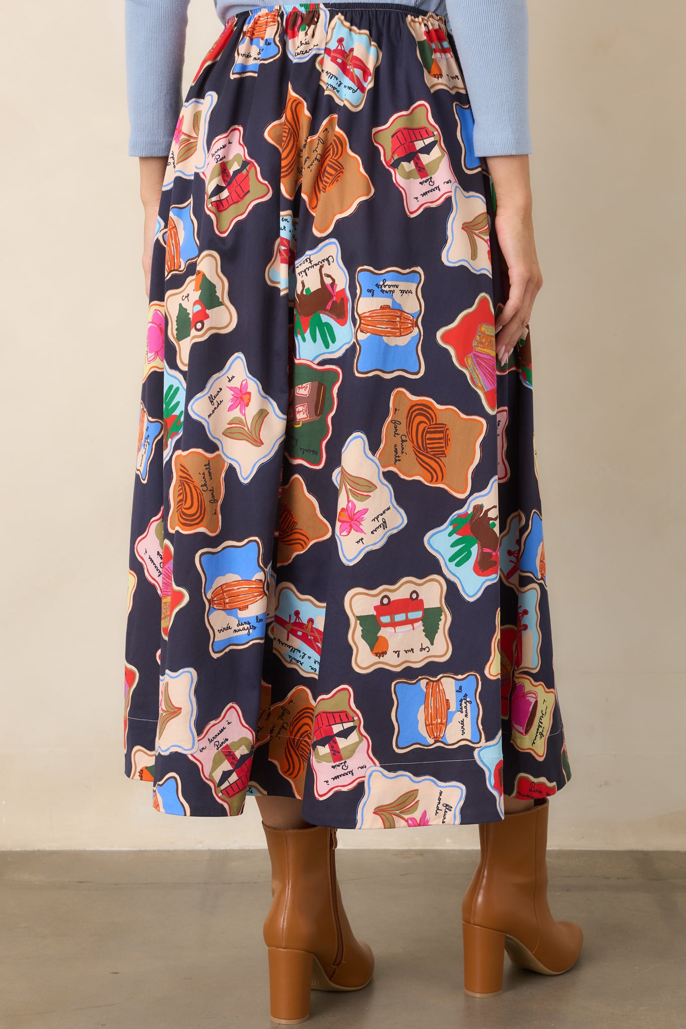Rear view of the midnight blue maxi skirt displaying its full flowing length, scattered illustrated motifs, and comfortable elastic waistband.
