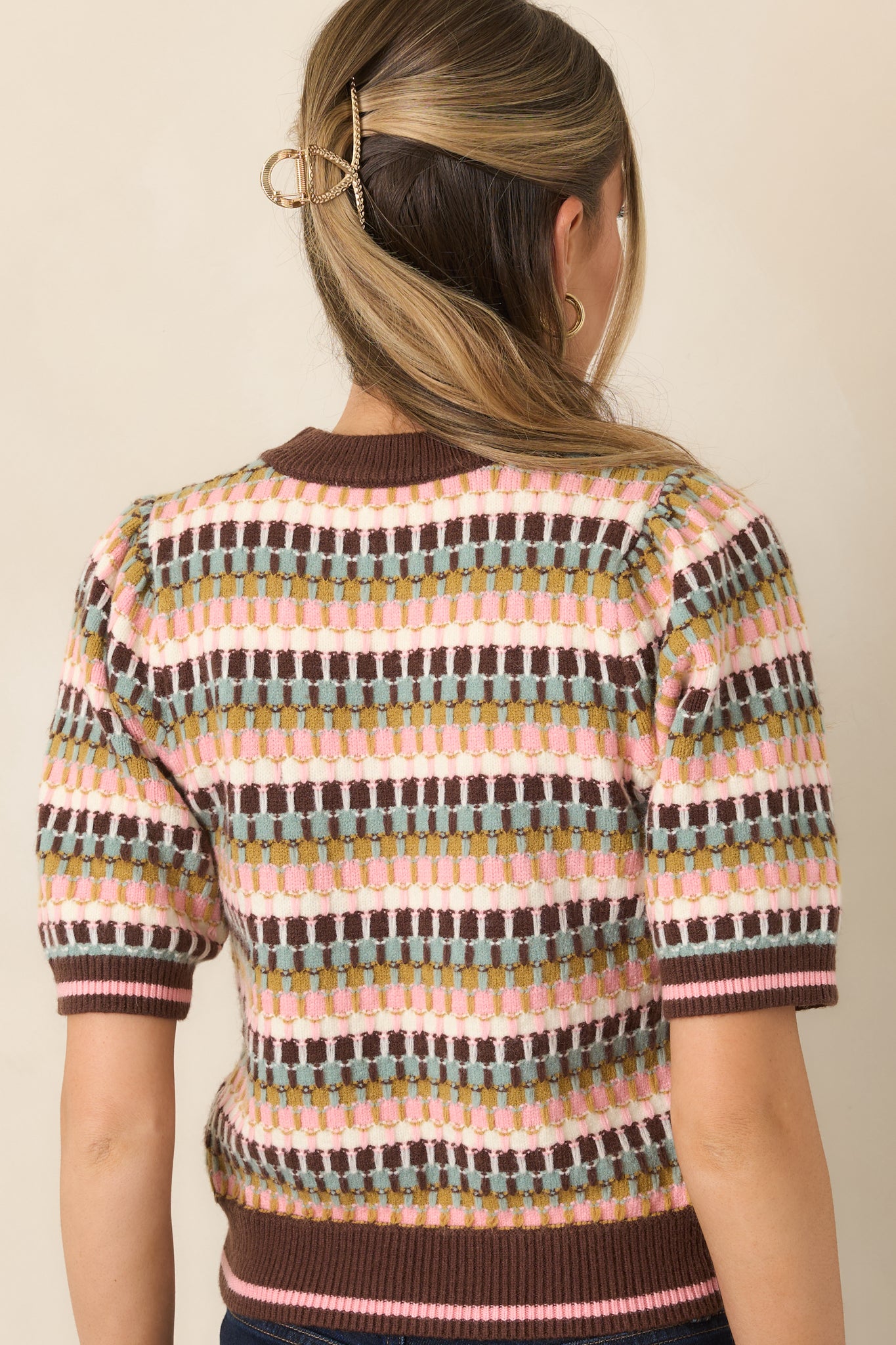 Rear view of the textured striped knit top featuring multicolor brown, sage, olive, blush pink, and ivory bands with ribbed trim.