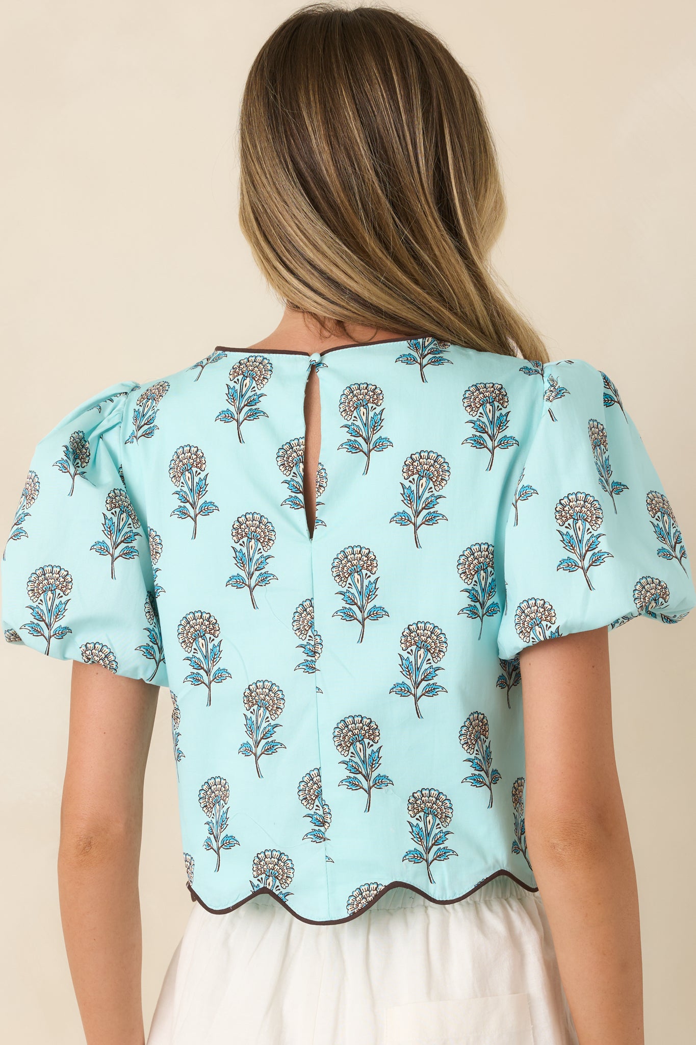 Rear view of the aqua crop top showcasing the floral print and softly structured silhouette.