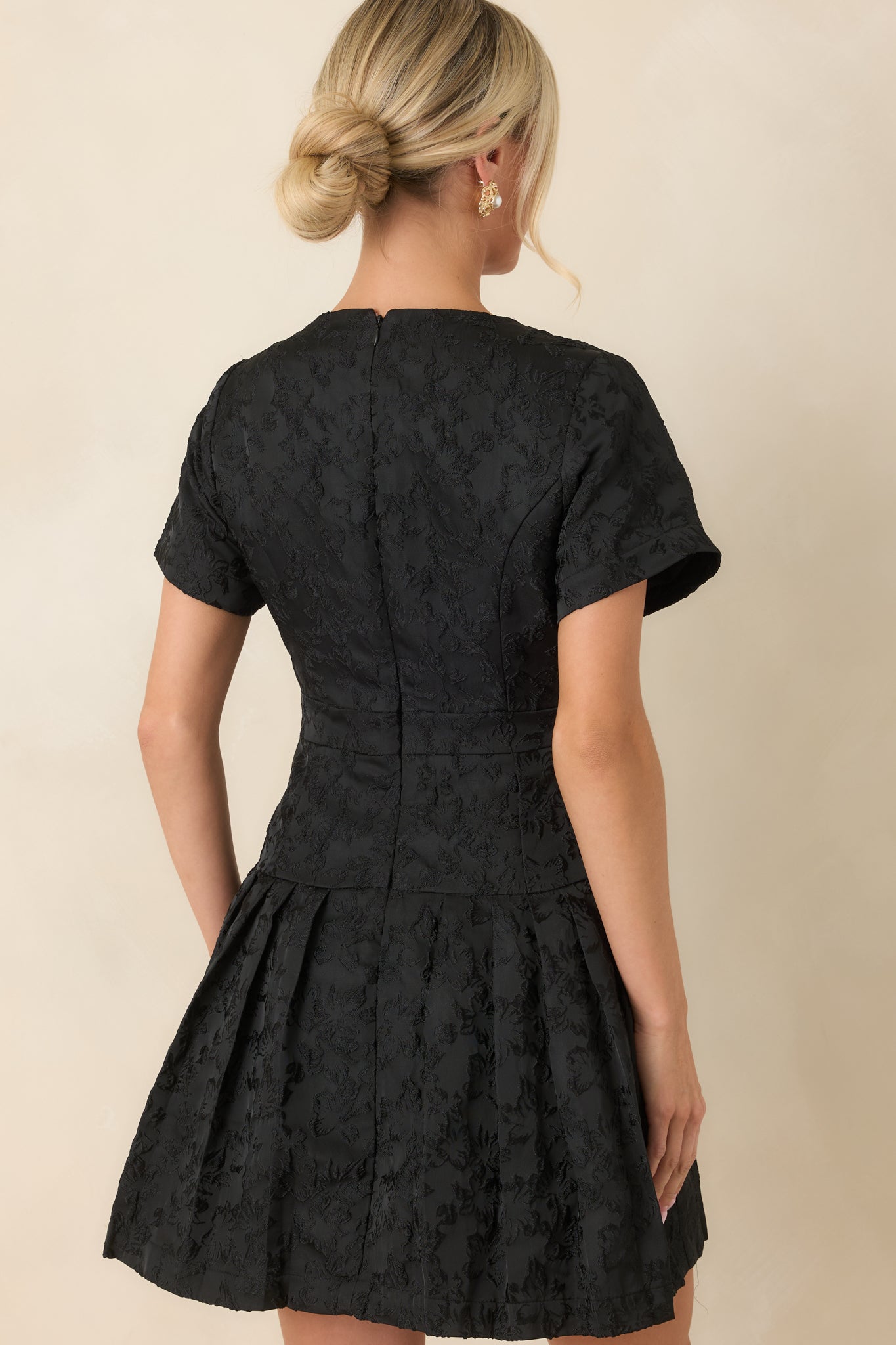 Rear view of the mini dress showcasing the concealed zipper and smooth jacquard finish.