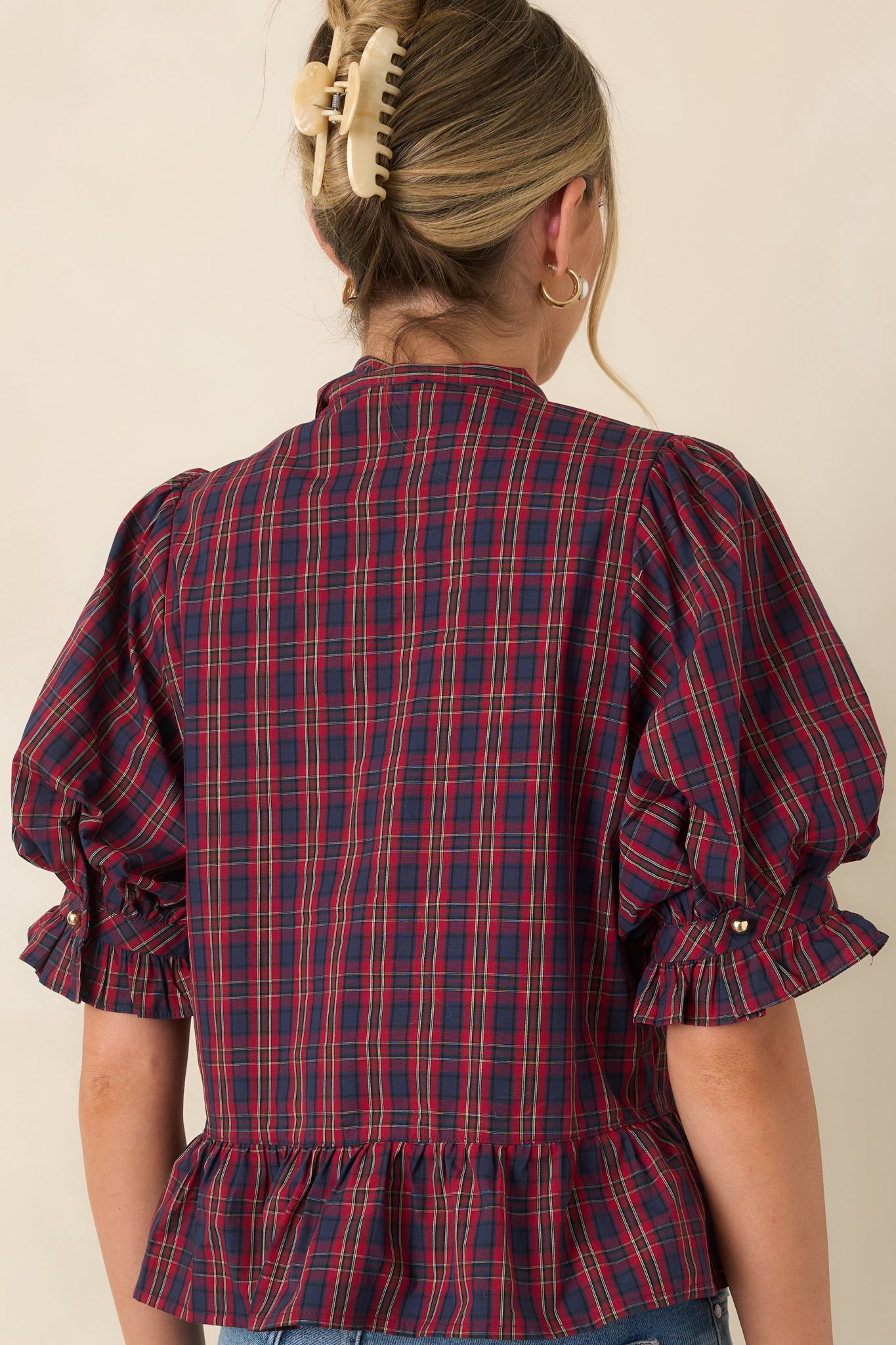 Rear view of the blouse showcasing the gathered peplum hem and smooth lined construction.