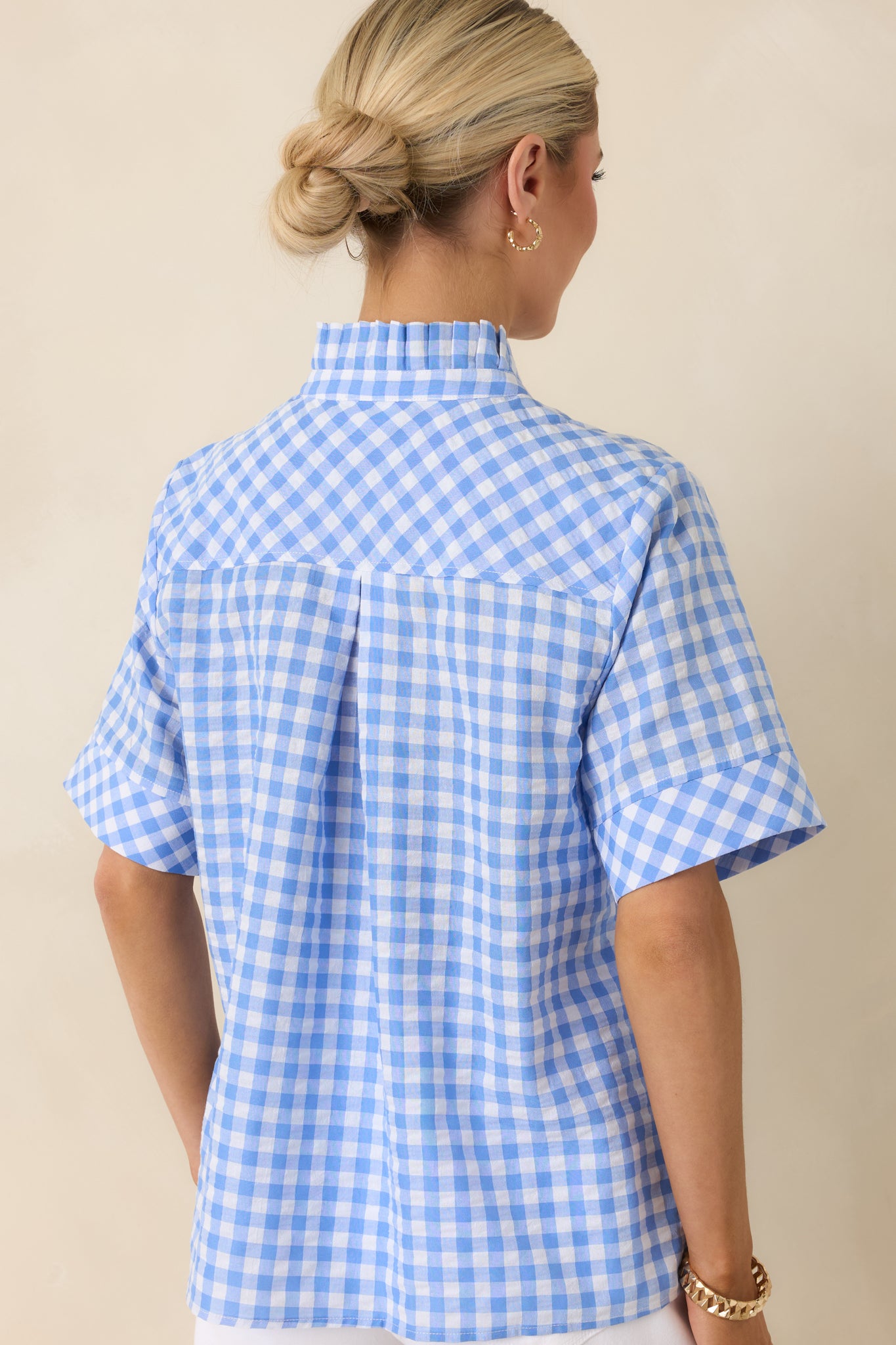 Rear view of blue gingham top with slightly boxy fit and short sleeves.