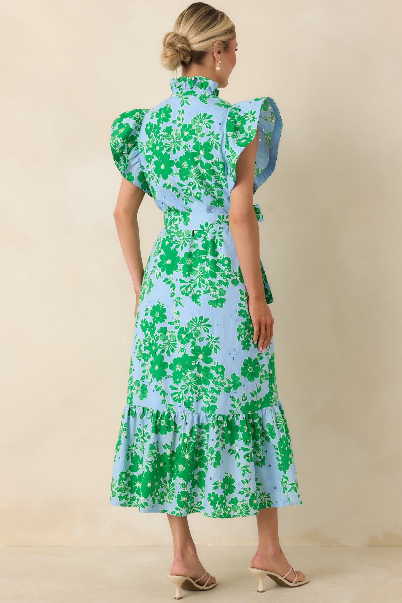 Rear view of blue and green midi dress with relaxed fit, ruffle hem, and tie belt.