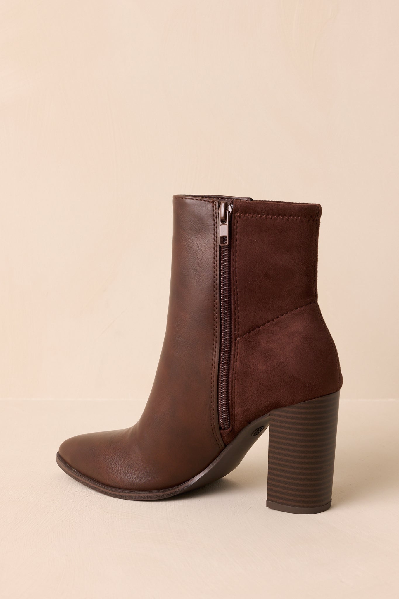 Rear view of the brown ankle boots showcasing the tonal faux suede back panels and stacked heels.