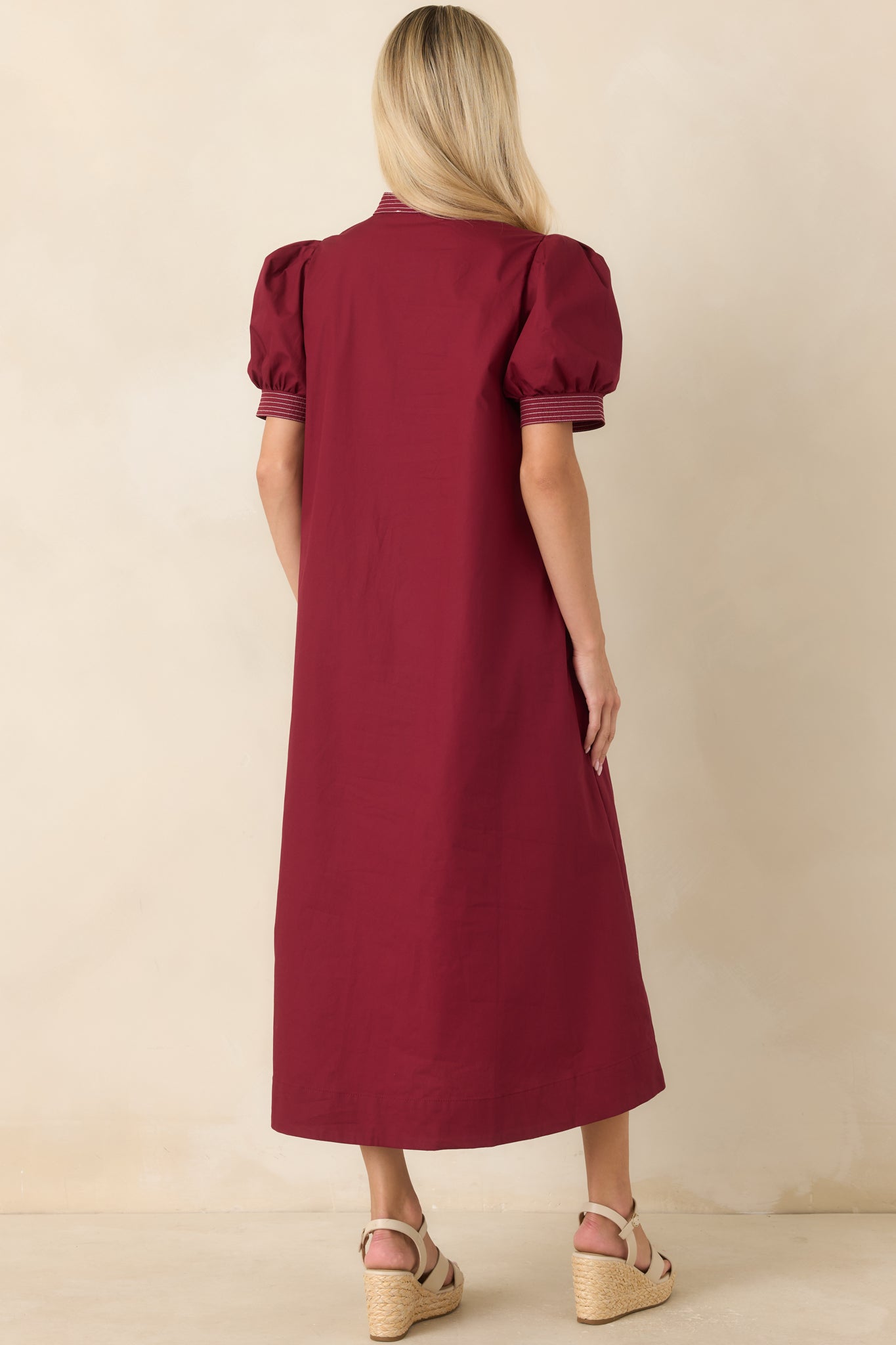 Rear view of the burgundy midi dress showcasing the flowing A-line silhouette and short puff sleeves.