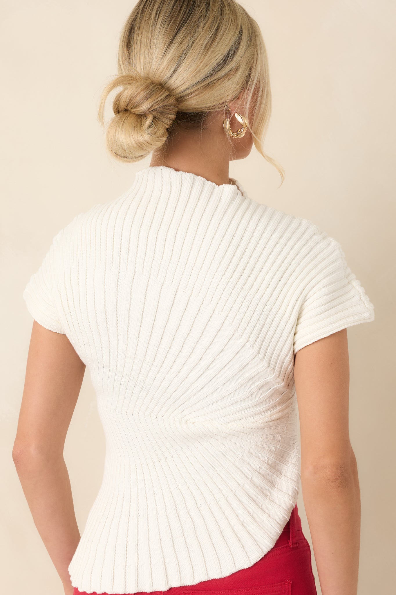 Rear view of the cotton ribbed top showcasing the textured knit design and asymmetrical hemline.