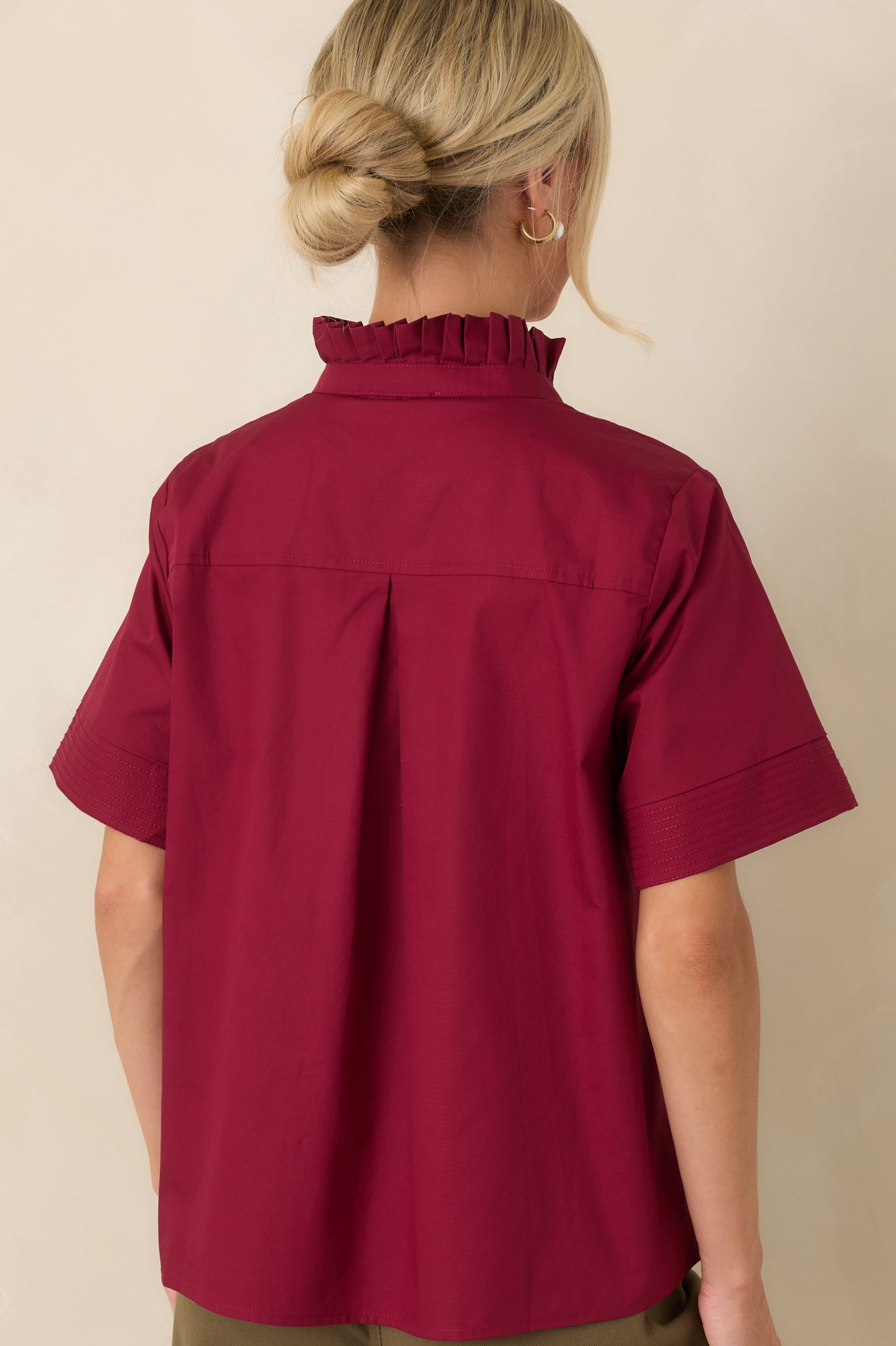 Rear view of the cotton top showcasing the center back pleat, relaxed drape, and clean silhouette.