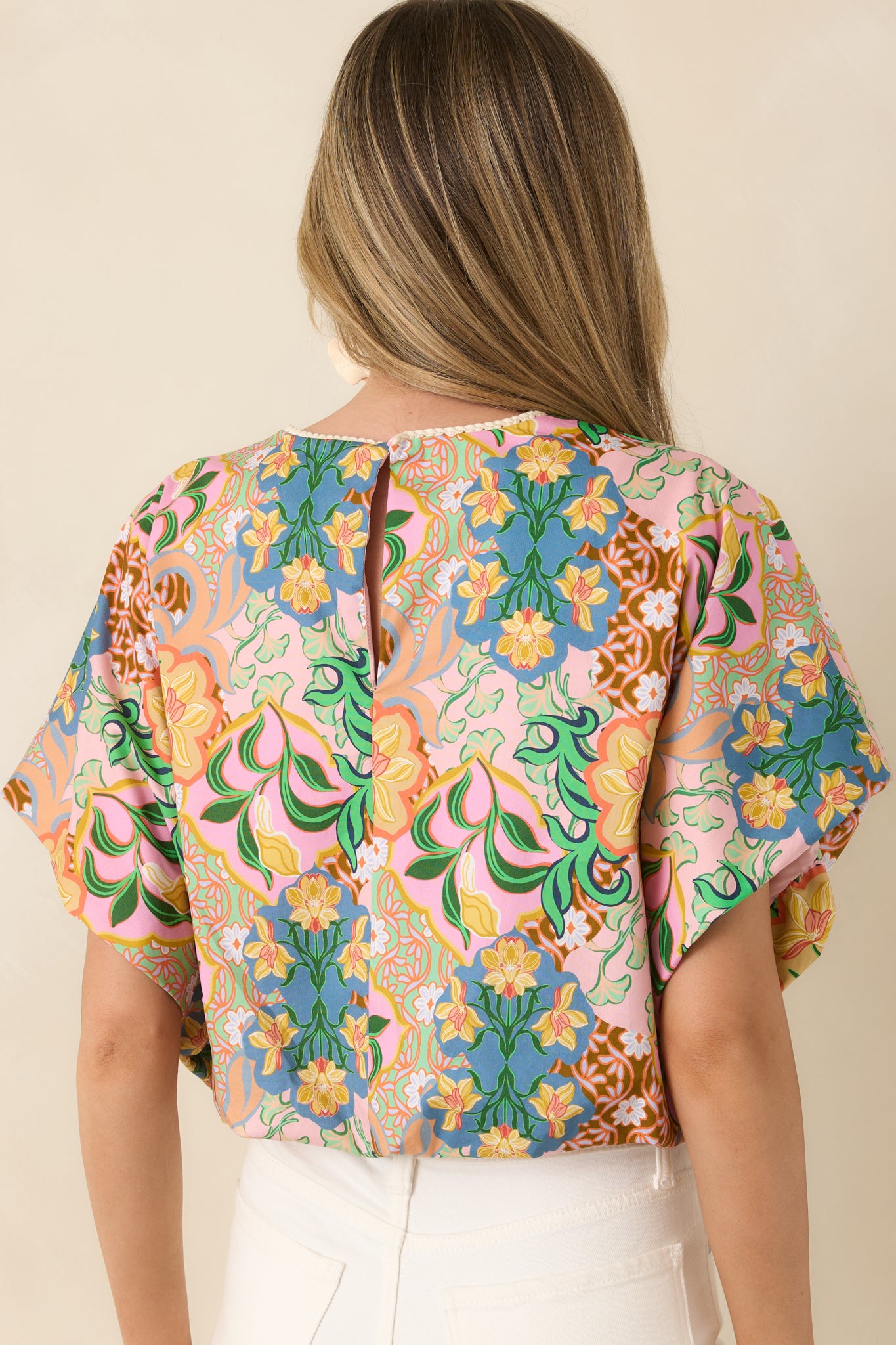 Rear view of cotton top with relaxed dolman sleeves and subtle keyhole closure.