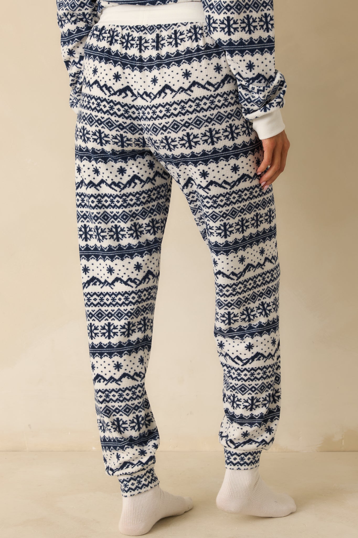 Rear view of ivory and navy Fair Isle jogger pajama pants, showing relaxed fit, cuffed hems, and soft brushed knit finish.