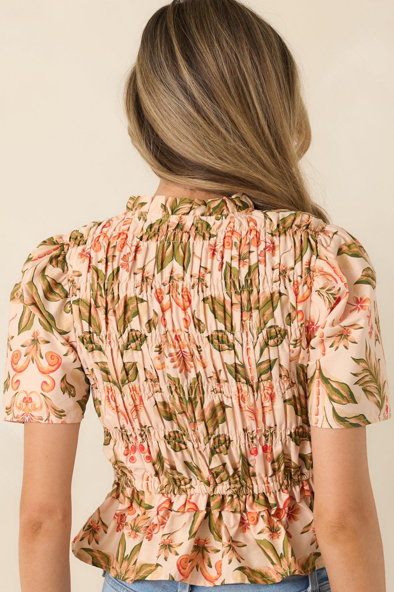 Rear view of floral top with elastic smocked bodice and ruffle hem.