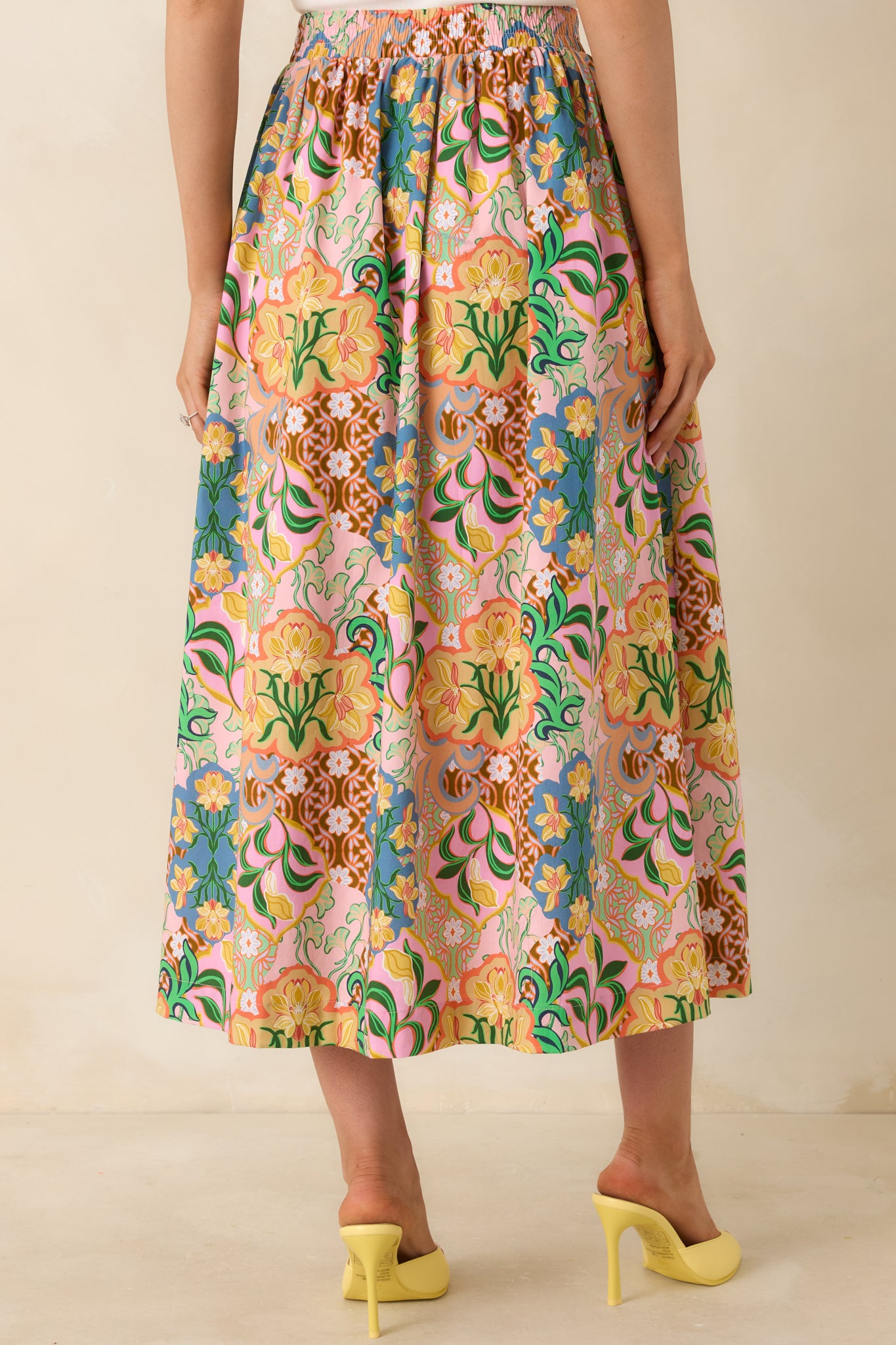 Rear view of full, gathered cotton skirt with elastic waistband, side pockets, and vibrant floral pattern.