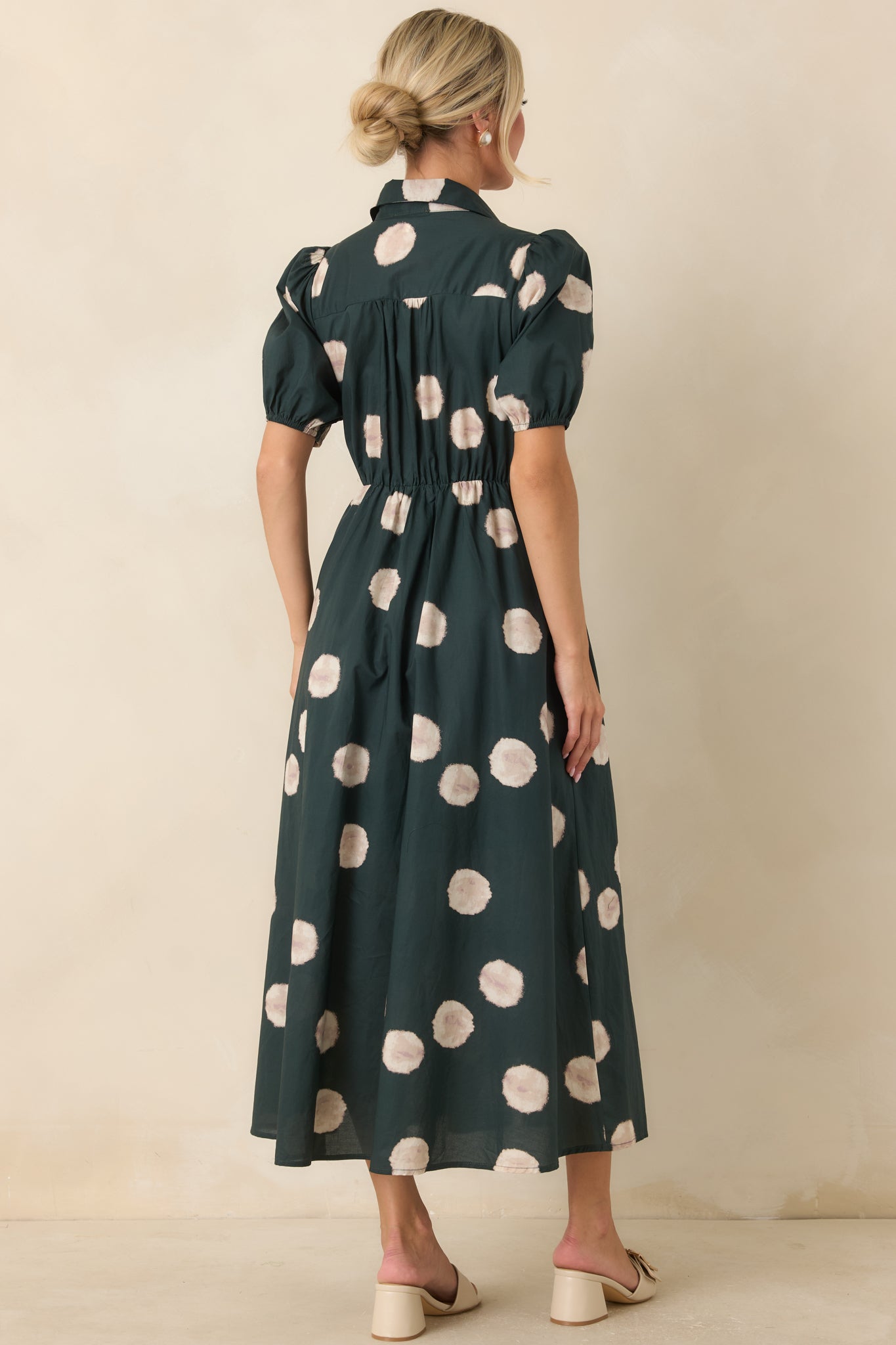 Rear view of the green midi dress featuring the elastic back waistband and the graceful drape of the A-line skirt.