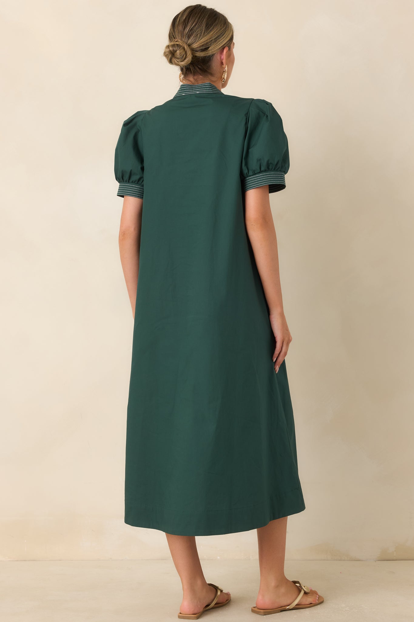 Rear view of the hunter green midi dress showcasing the flowing A-line silhouette and short puff sleeves.