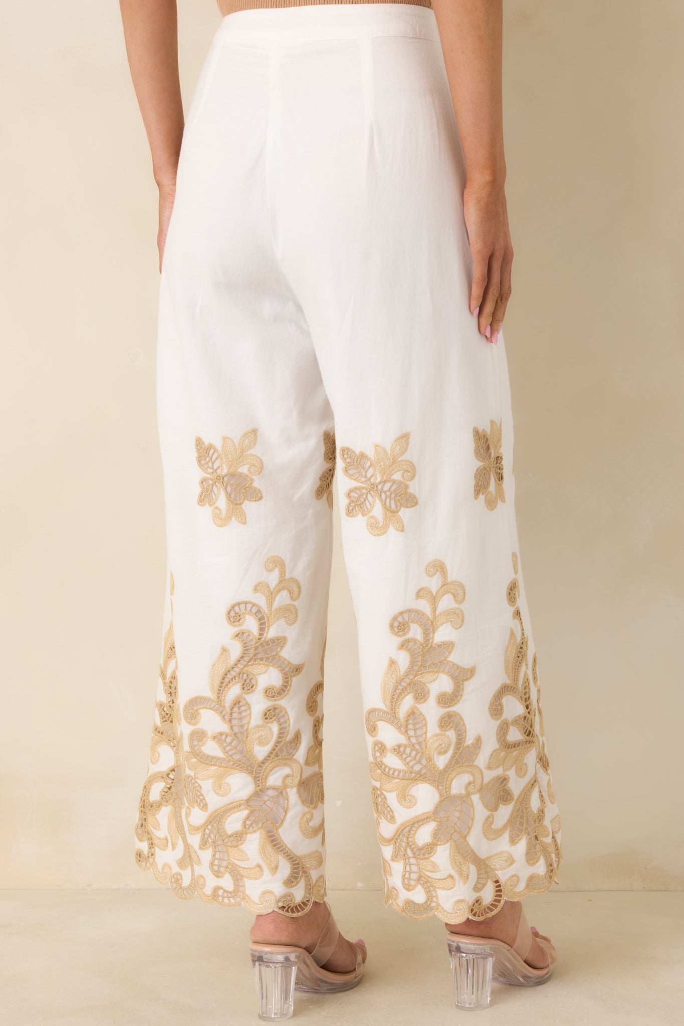 Rear view of ivory high-rise pants with clean finish and concealed closure.