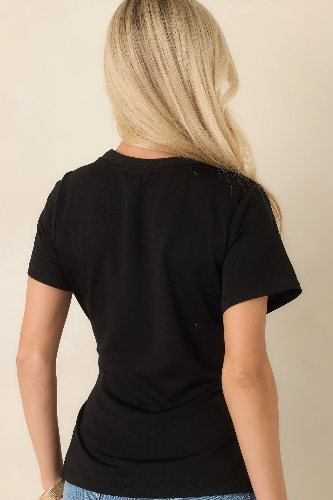 Rear view of the knit top showcasing the fitted silhouette, short sleeves, and clean finish.