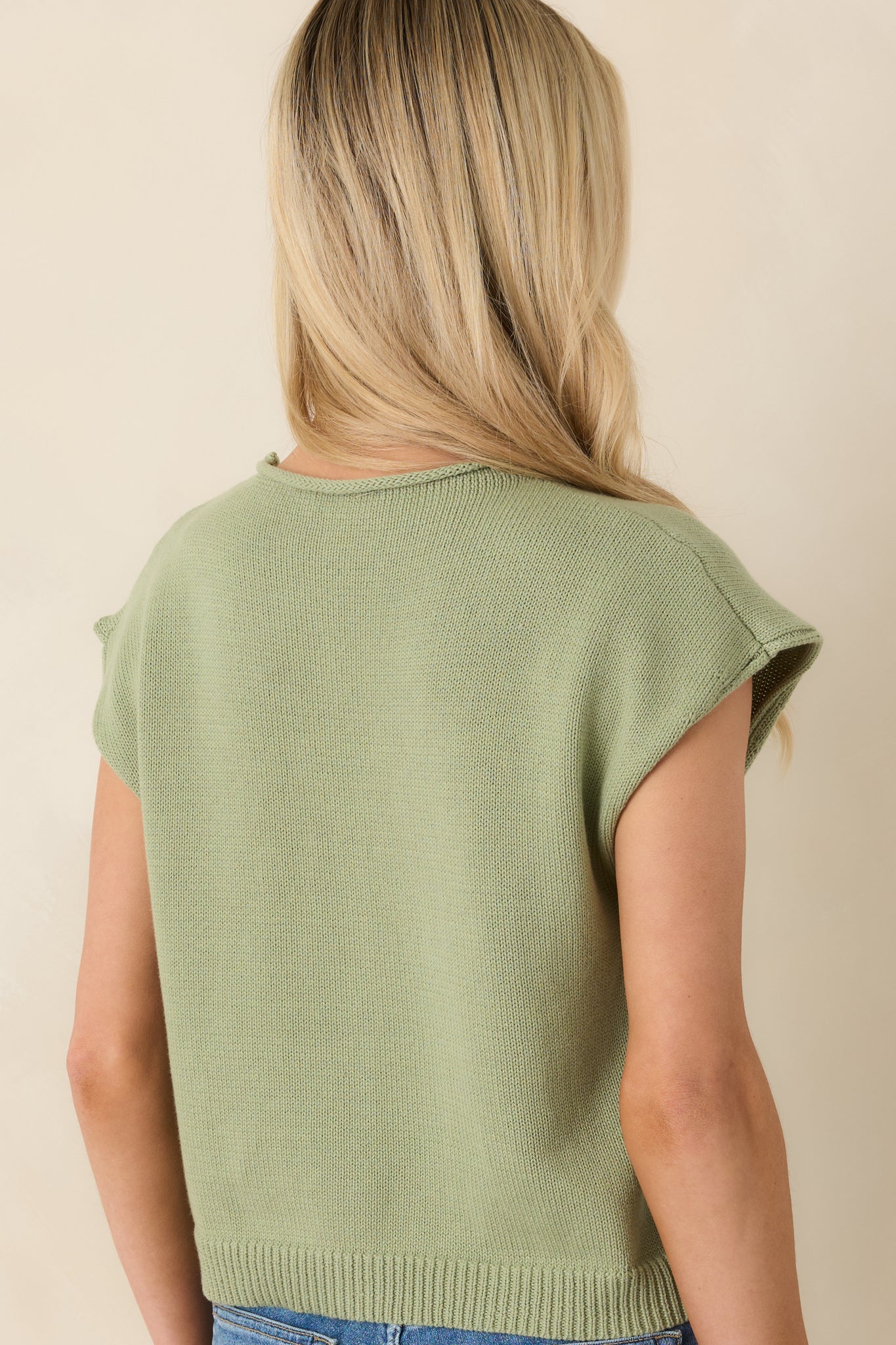 Rear view of light green sleeveless knit top with smooth finish.