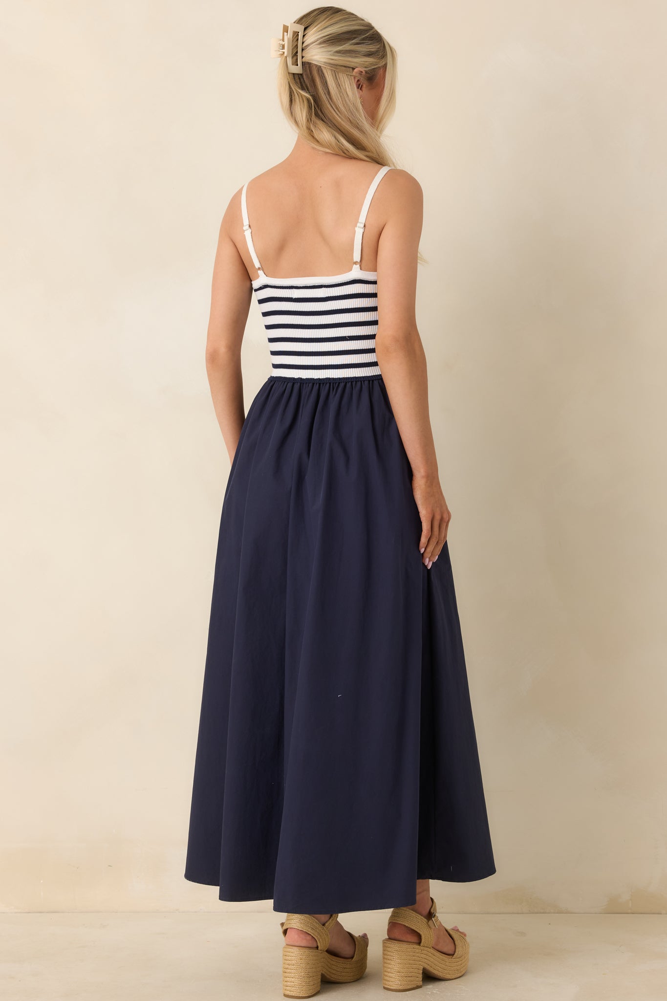 Rear view of midi dress showing adjustable straps, gathered skirt, and soft woven fabric.