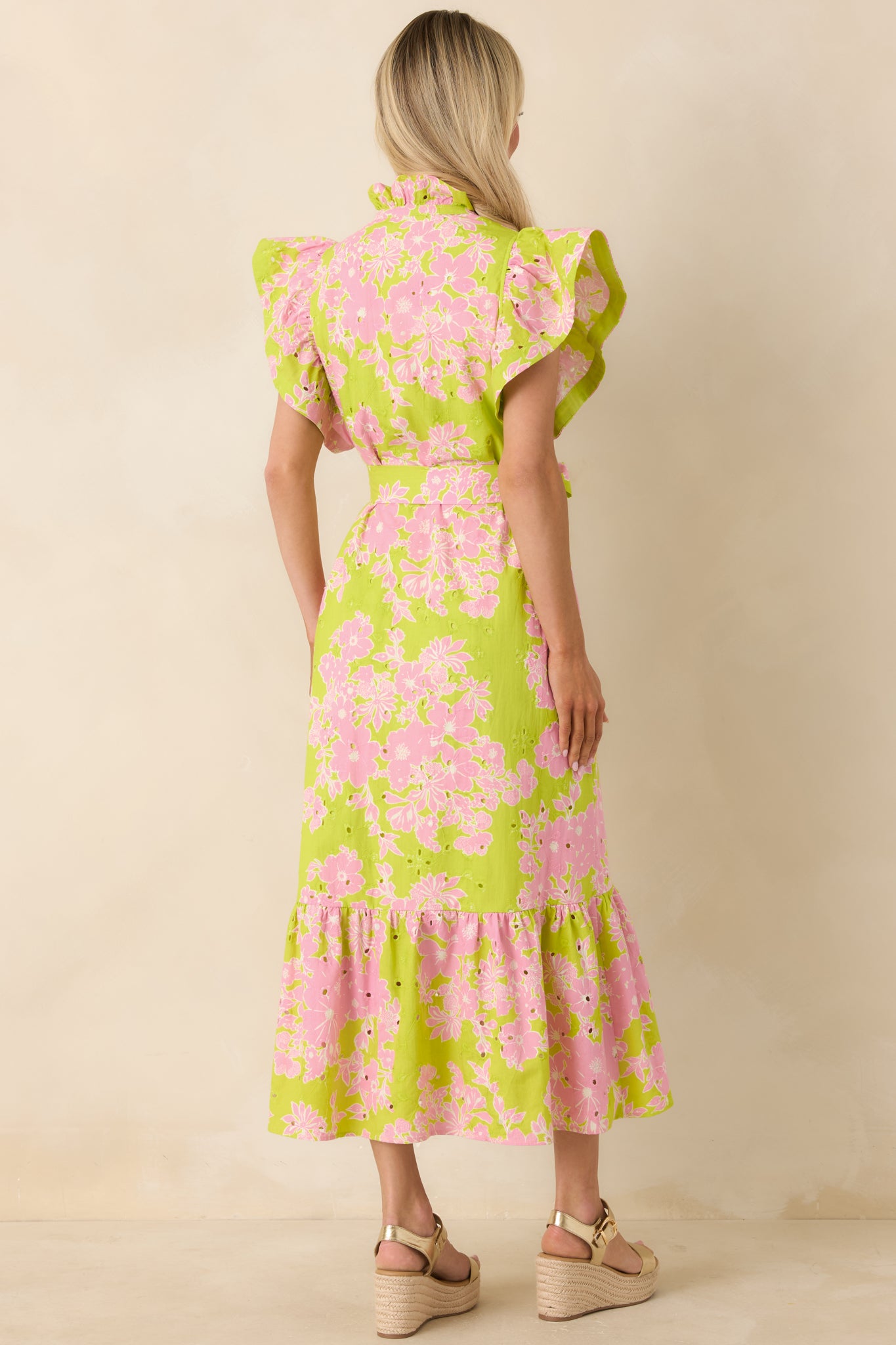Rear view of chartreuse and pink midi dress with relaxed fit, ruffle hem, and tie belt.