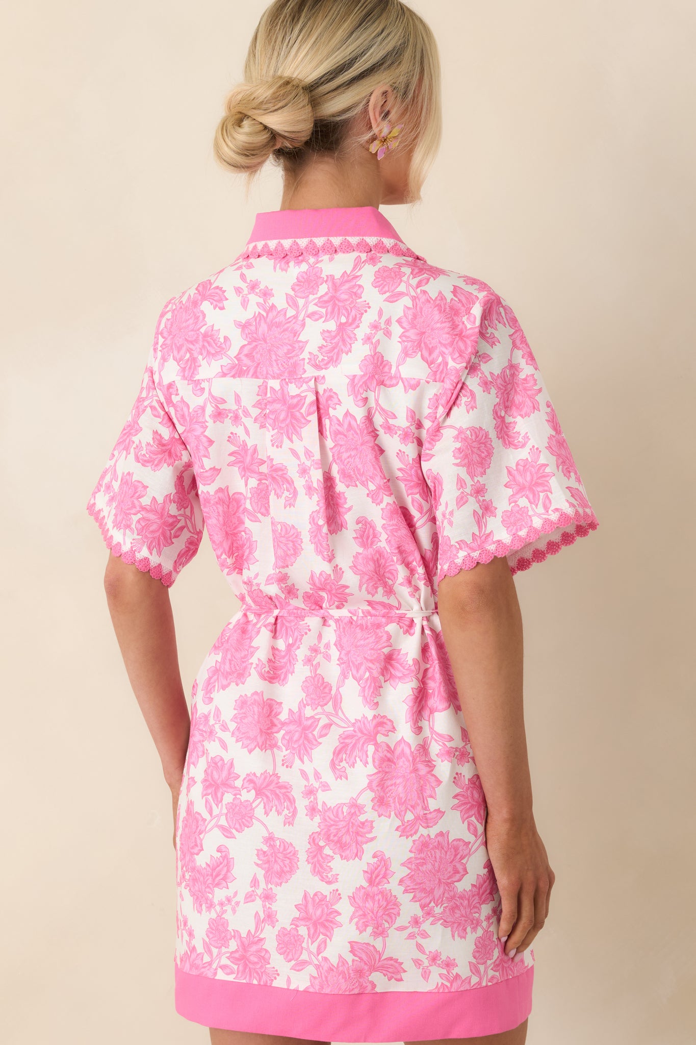 Rear view of floral mini dress with defined waist and softly structured silhouette.