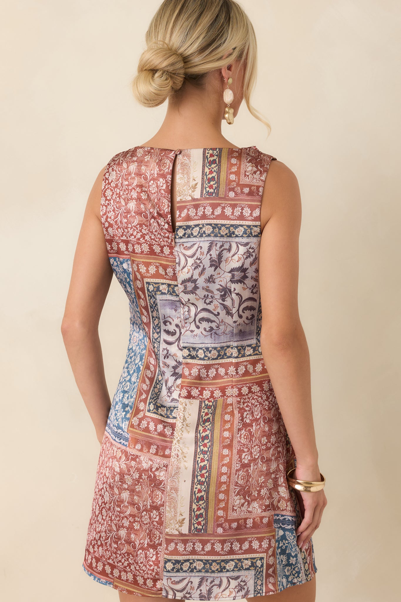 Rear view of the mini dress showcasing the keyhole button closure and gently flared skirt.