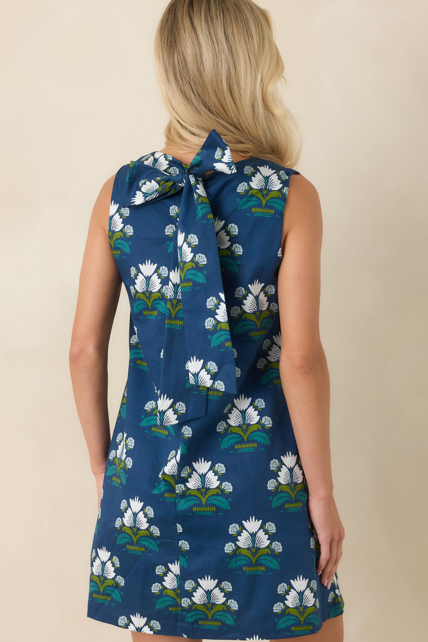 Rear view of the mini dress showcasing the oversized self-tie bow and relaxed silhouette.