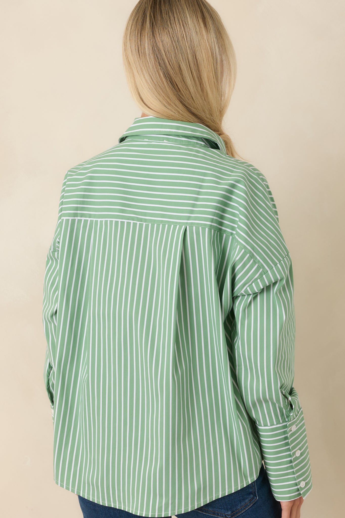 Rear view of the mint striped shirt highlighting the relaxed oversized fit, smooth back panel, and box pleat detail.