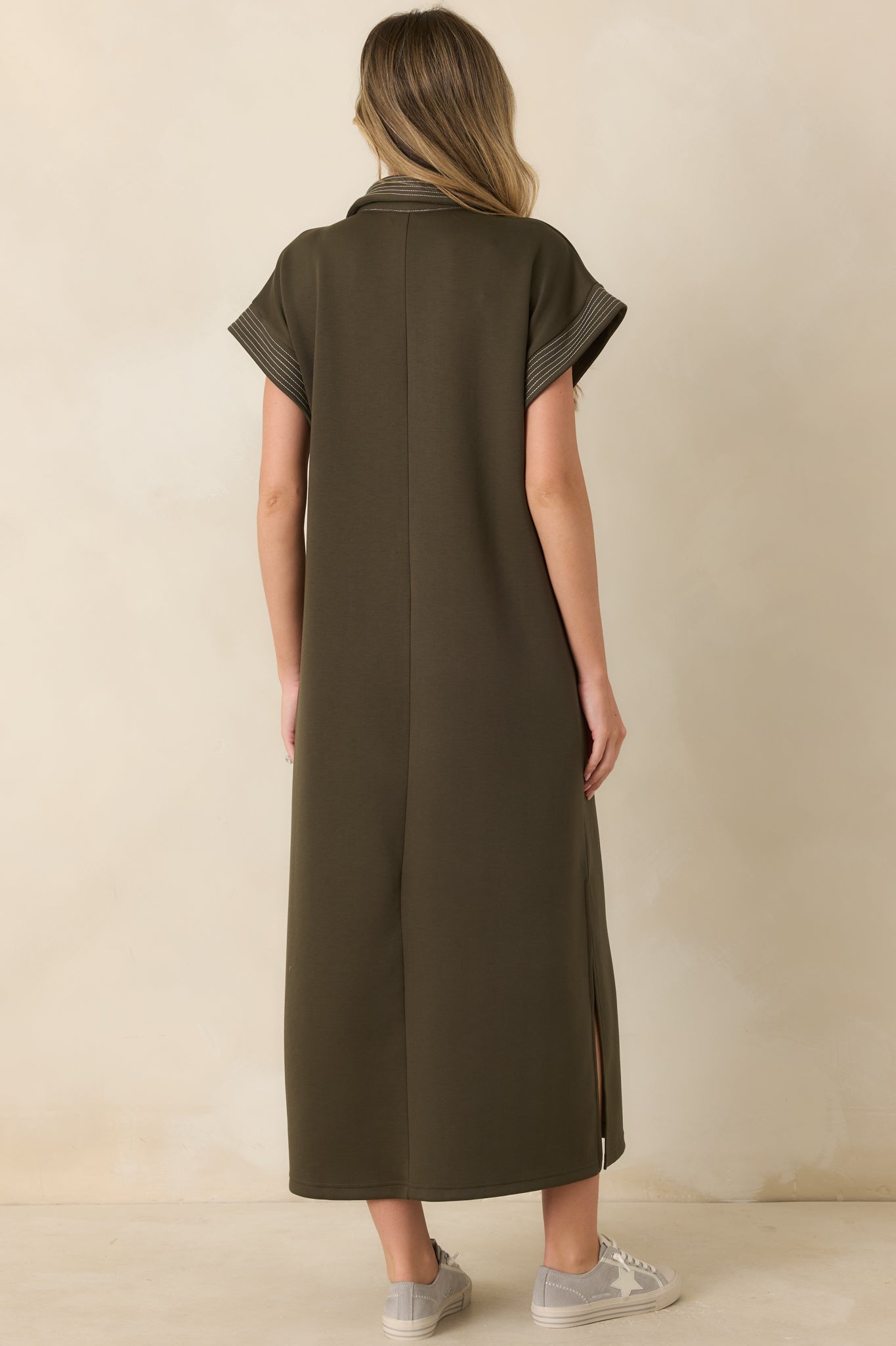 Rear view of the olive knit maxi dress showcasing the relaxed silhouette, smooth knit texture, and contrast trim details.