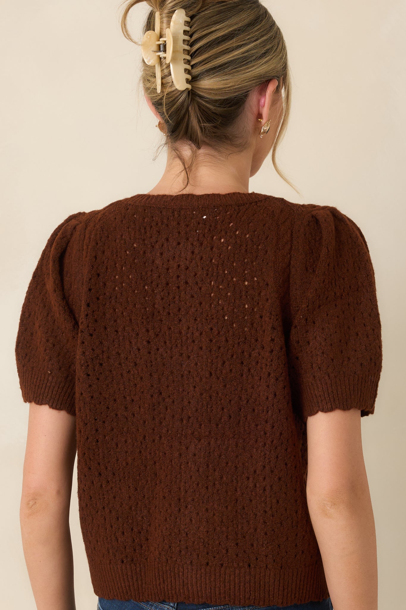 Rear view of the pointelle knit cardigan highlighting the delicate pattern, puff sleeves, and ribbed finishing.