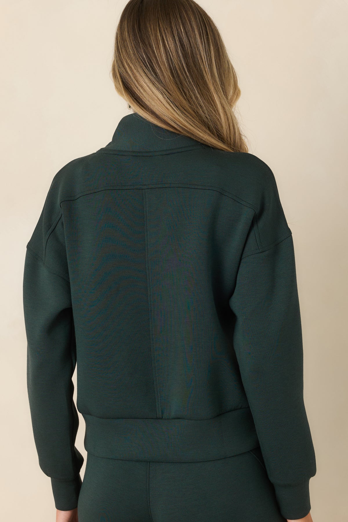 Rear view of the pullover showcasing the relaxed silhouette, dropped shoulders, and wide banded hem.