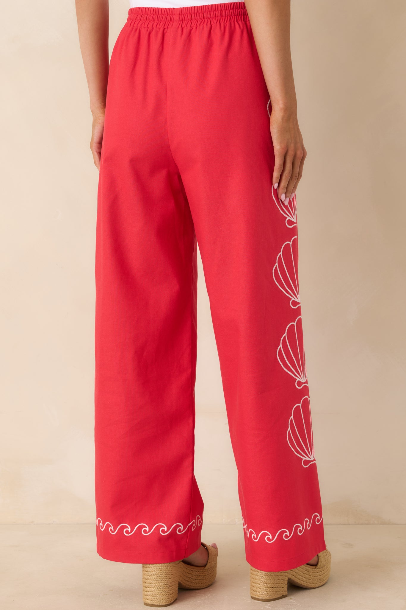 Rear view of red wide leg pants with elastic waistband and relaxed fit.