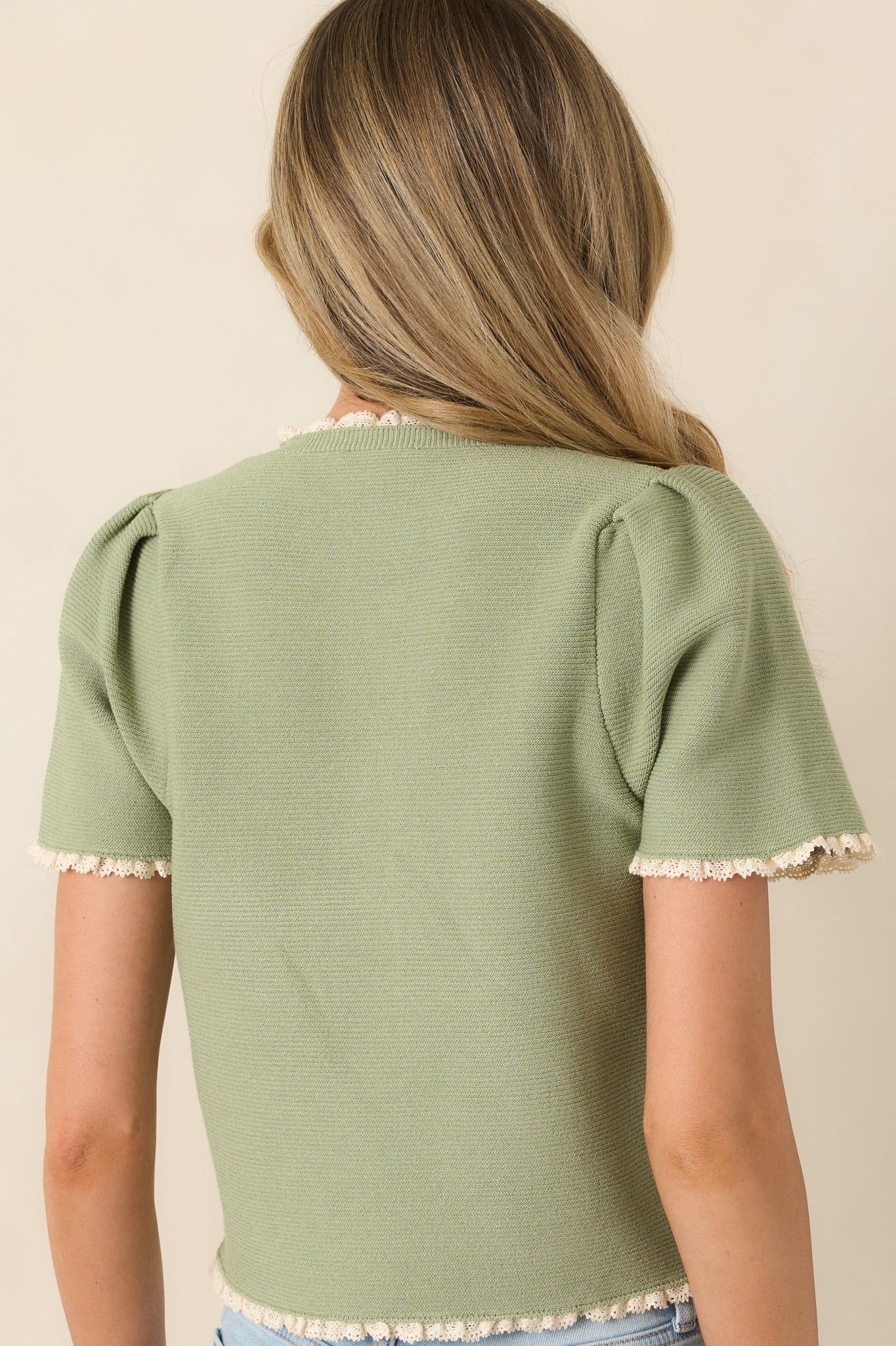 Rear view of short sleeve knit top with smooth lightweight finish.
