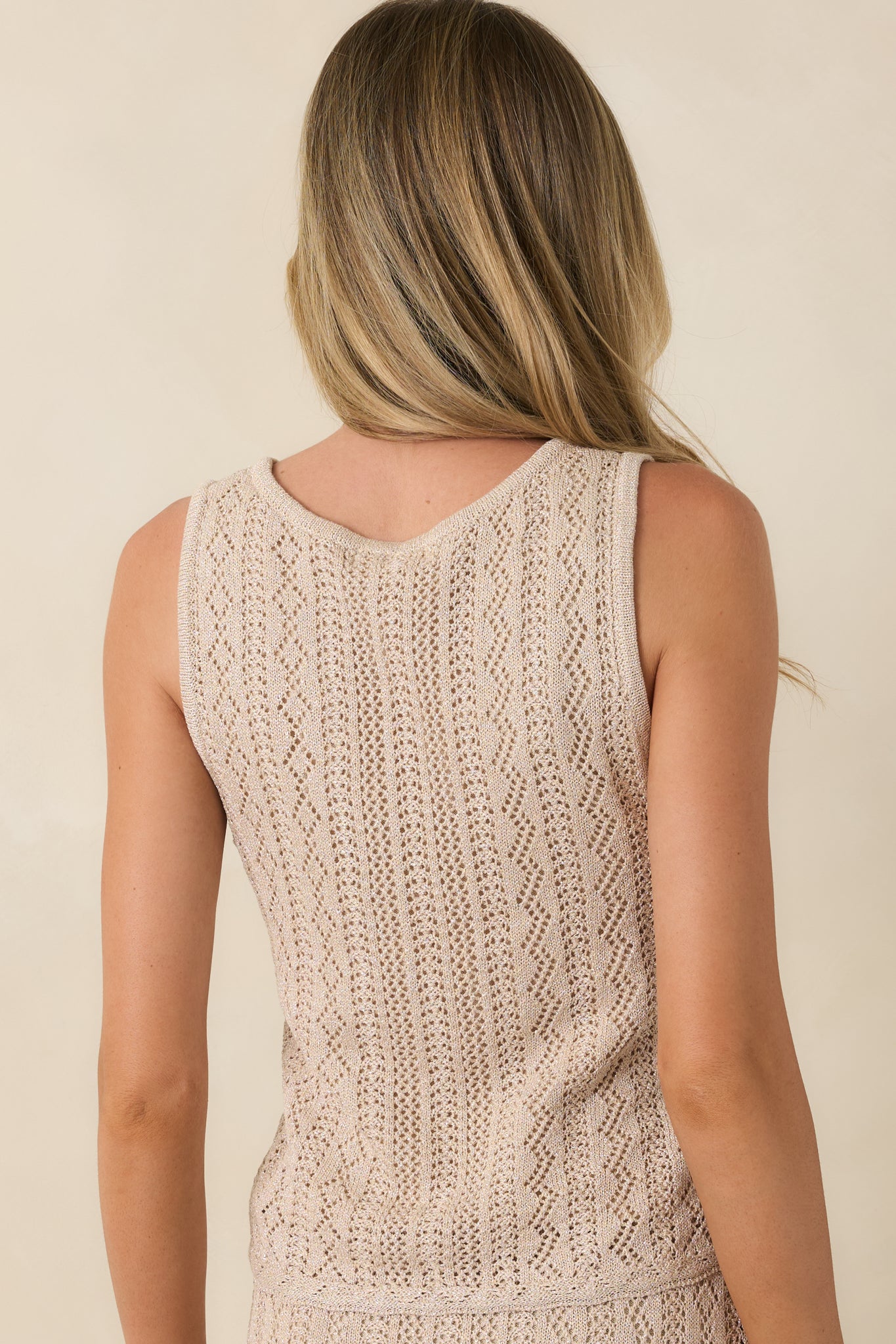 Rear view of gold metallic knit tank with sleeveless styling and pointelle texture.
