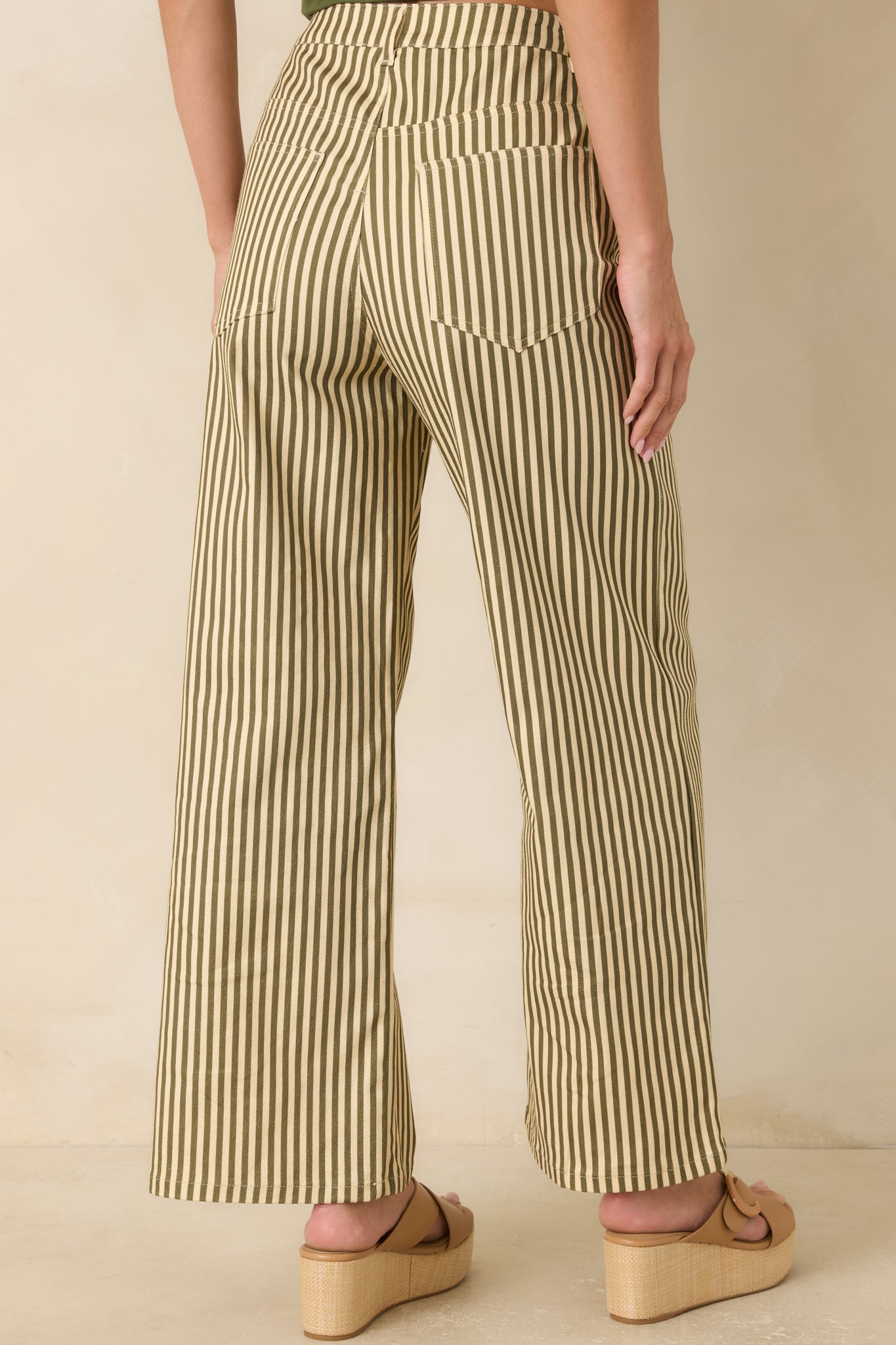 Rear view of the striped wide-leg pants featuring functional back pockets and a relaxed tailored silhouette.