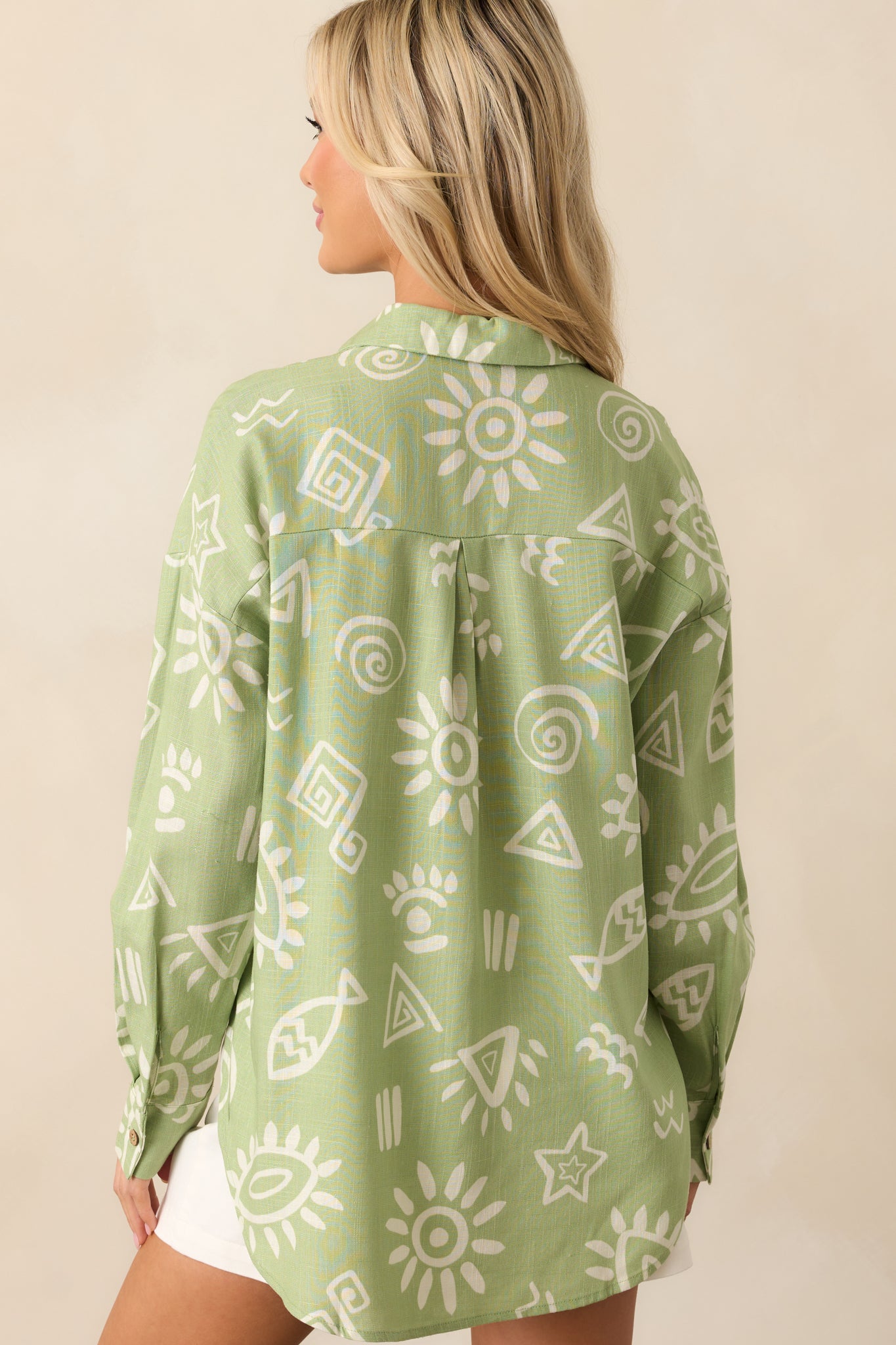 Rear view of the top displaying the all-over tropical print, relaxed drop shoulder cut, and gentle drape of the linen blend fabric.