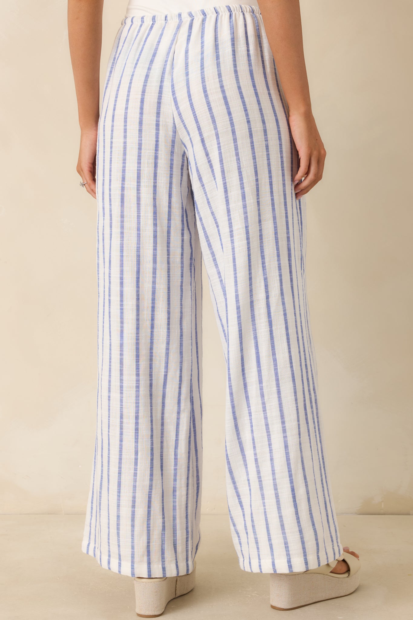 Rear view of the blue stripe pants featuring a relaxed wide-leg silhouette and smooth elastic waistband finish.