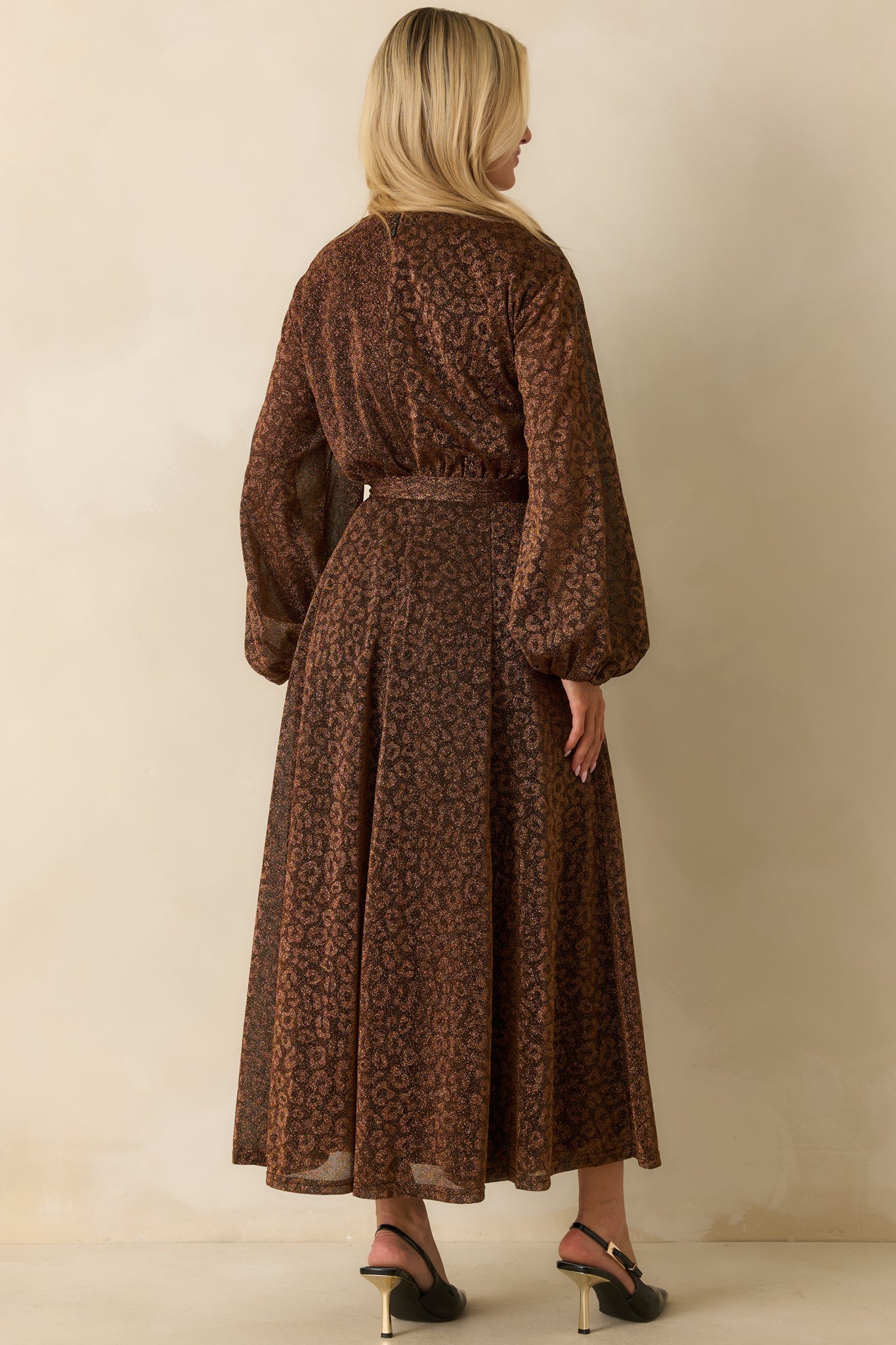 Rear view of the brown shimmer midi dress showing the elastic waist, flowing skirt, and long sleeves.