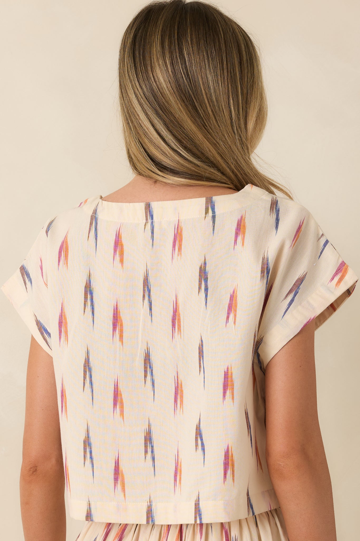 Rear view of the ivory crop top with dolman cap sleeves and a relaxed silhouette.