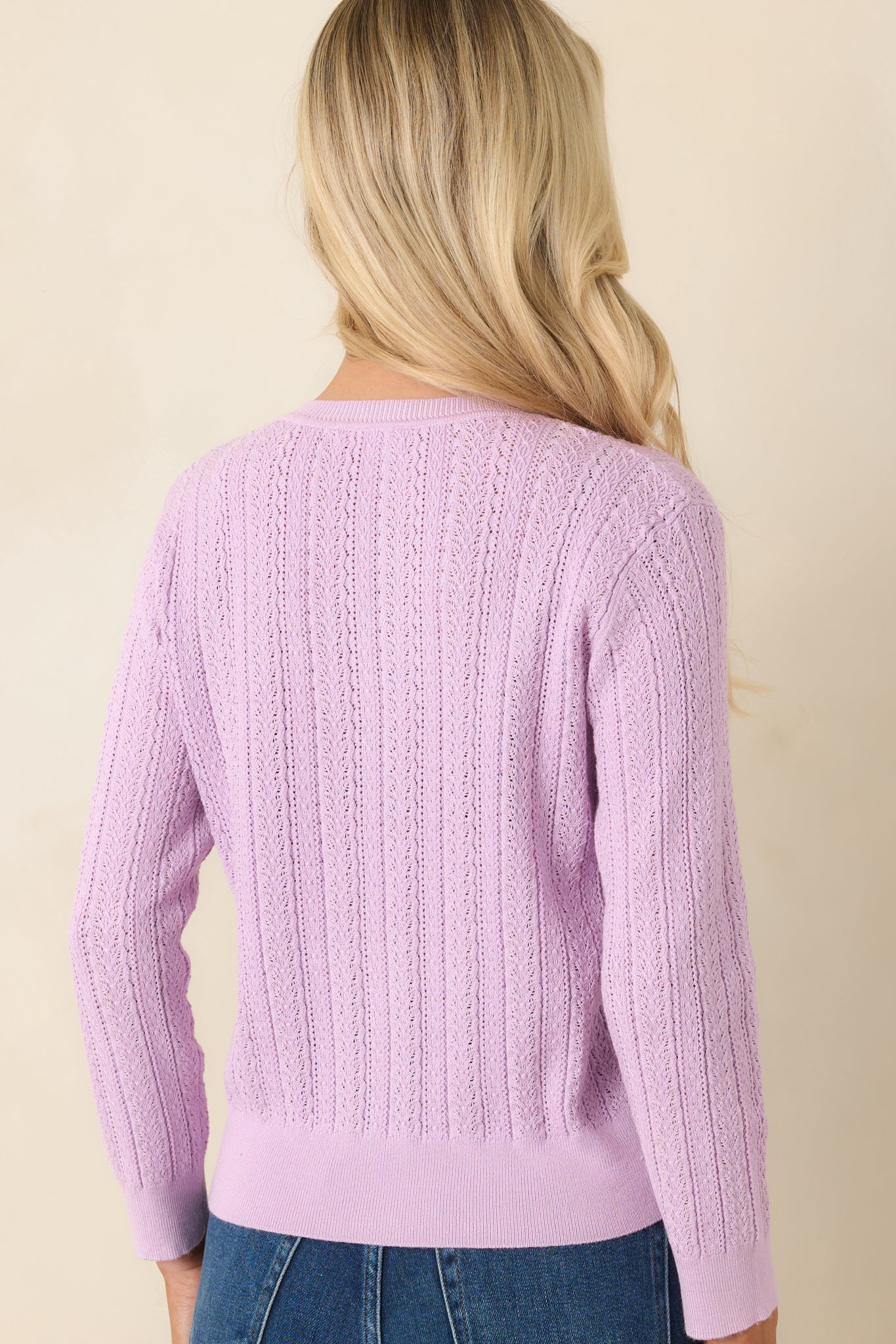 Rear view of the lilac cardigan, showing the continuous cable knit design and lightweight feel.