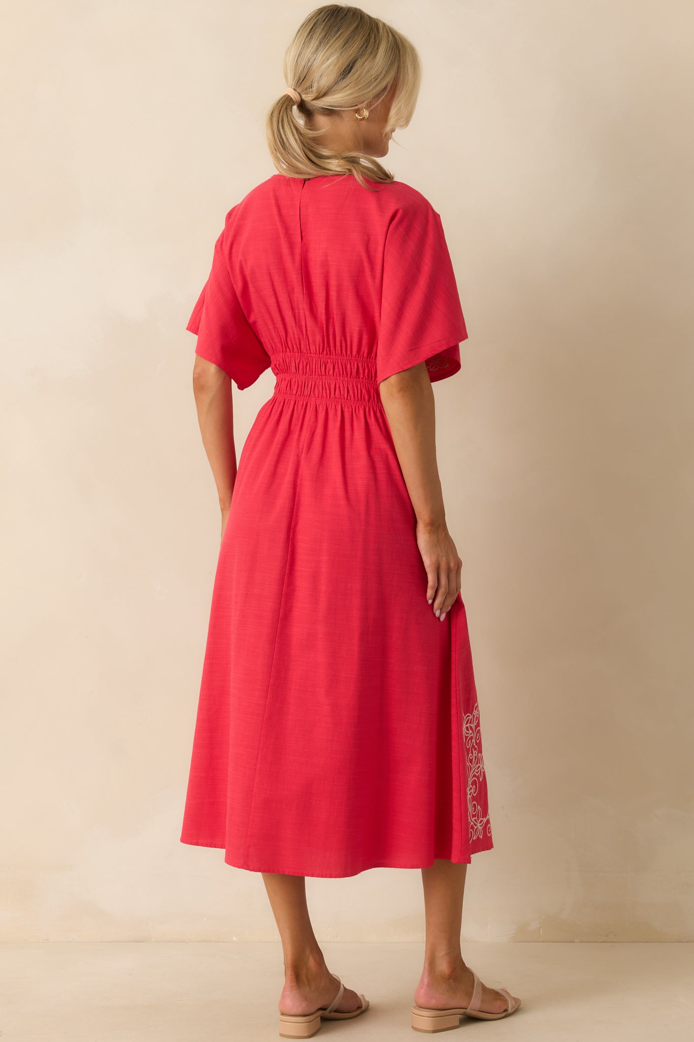 Rear view of the midi dress with keyhole button closure and smocked waistline.
