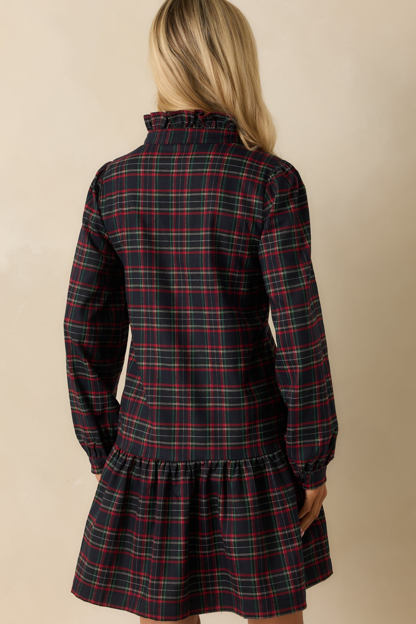 Rear view of navy multi plaid mini dress, showing long sleeves, tiered ruffle hem, and relaxed fit.