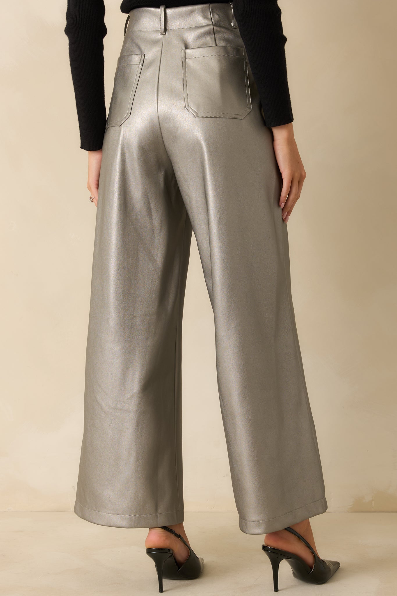 Rear view of the grey metallic pants featuring a smooth, structured fit and wide leg drape