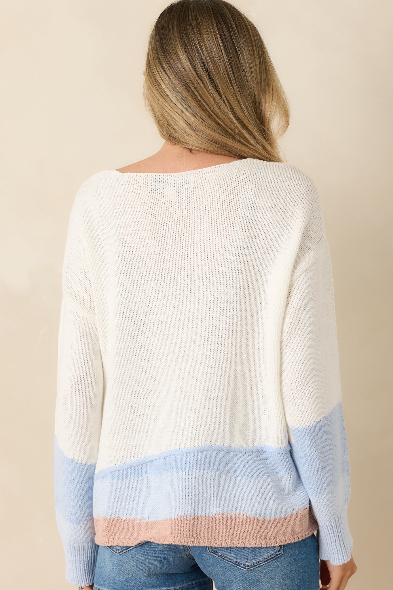 Rear view of the white knit sweater featuring a relaxed fit, lightweight knit construction, and clean colorblock design.