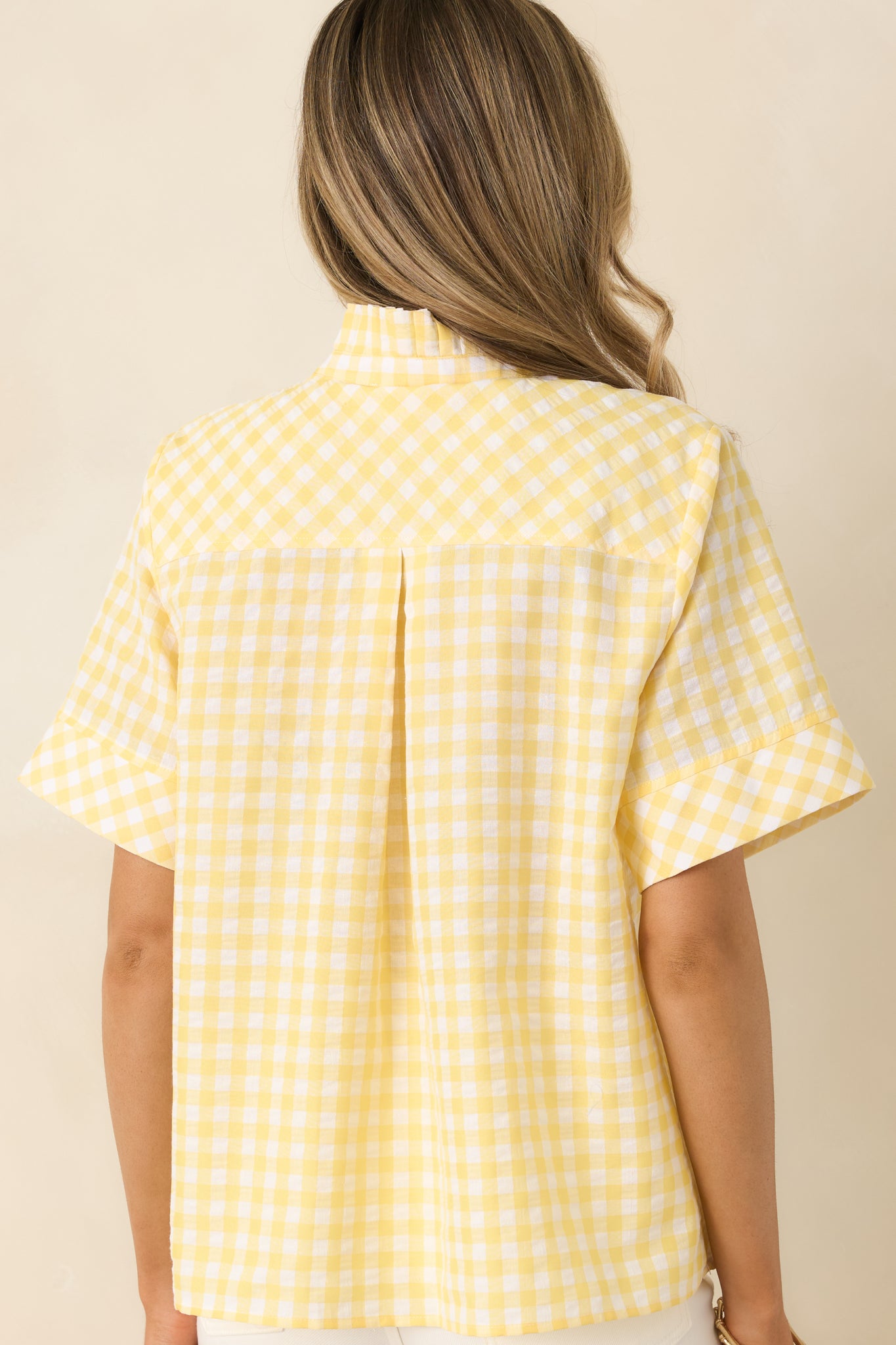 Rear view of yellow gingham top with relaxed fit and short sleeves.