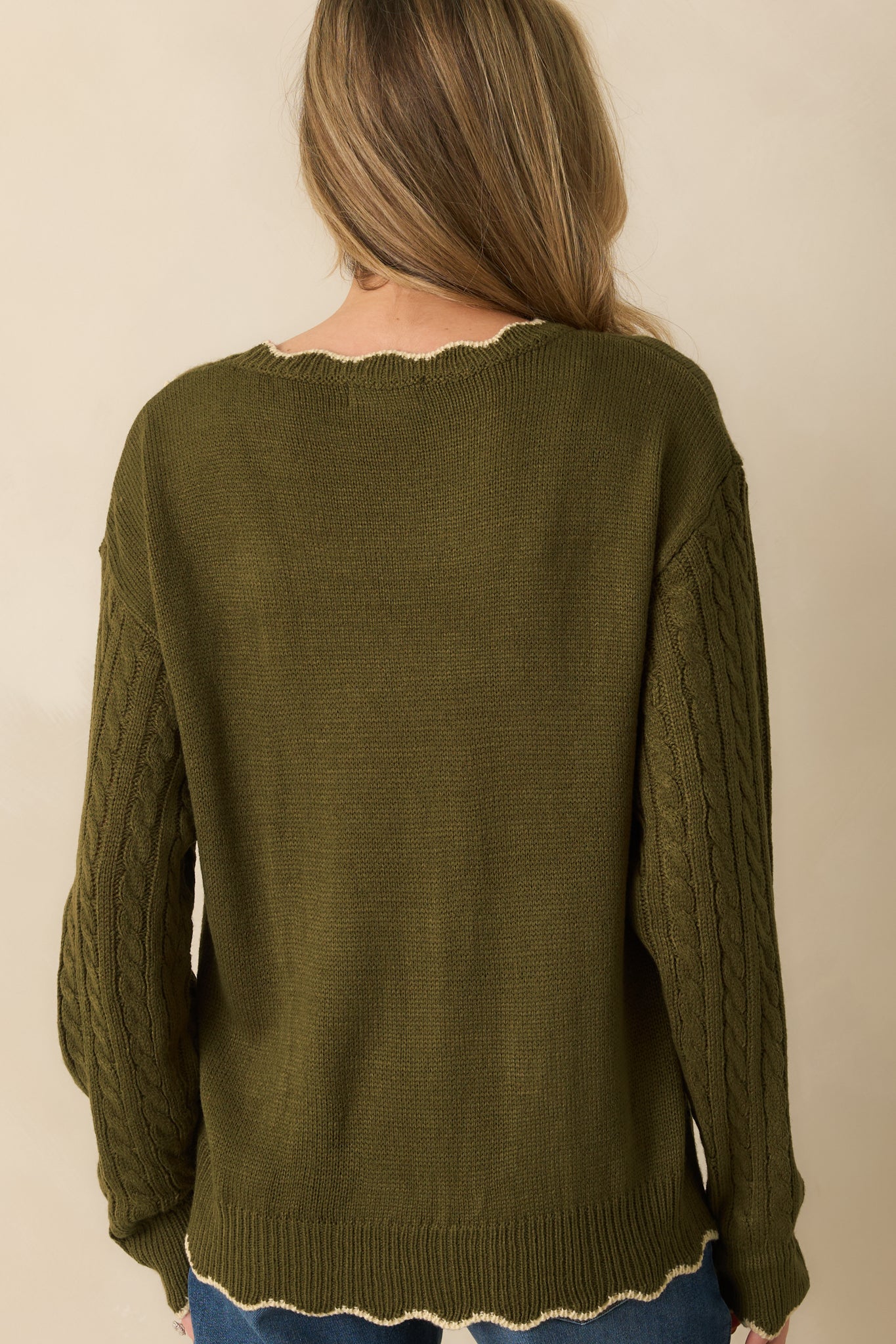 Rear view of the olive cable knit sweater with long sleeves and ribbed trim