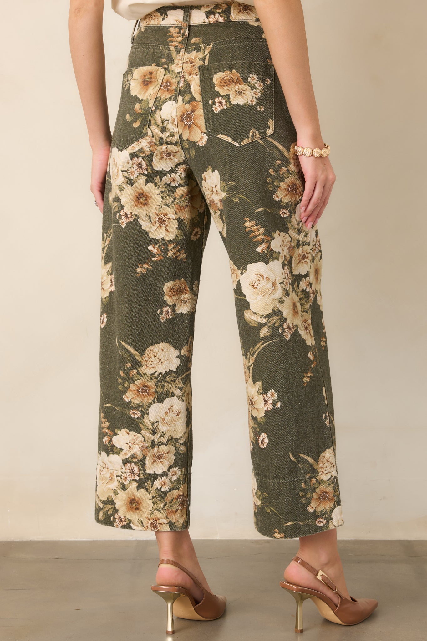 Rear view of the olive green floral pants showing the high-rise fit, back patch pockets, and relaxed wide-leg shape.