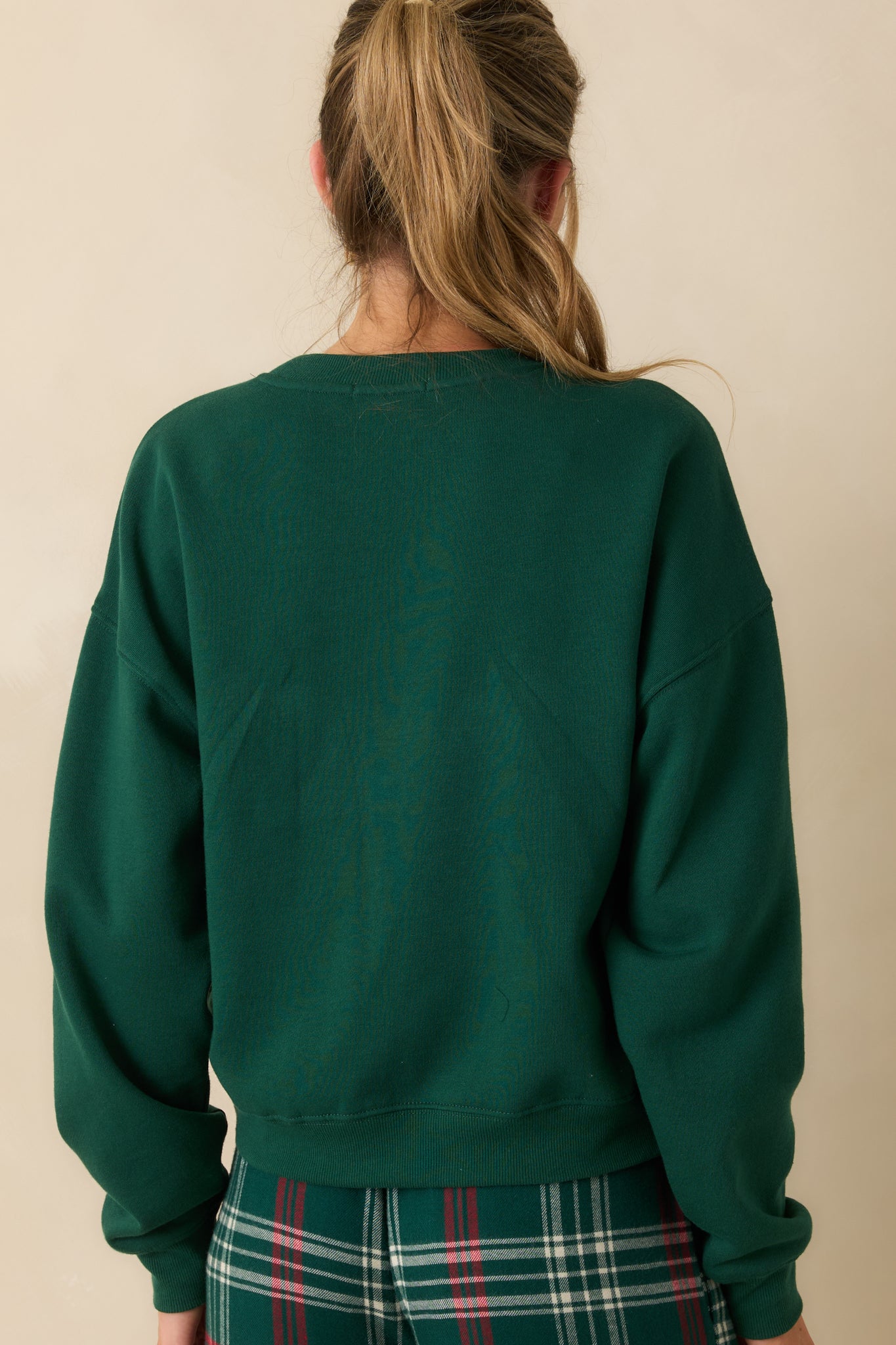 Rear view of oversized green sweatshirt, showing long sleeves, relaxed fit, and smooth midweight fleece finish.